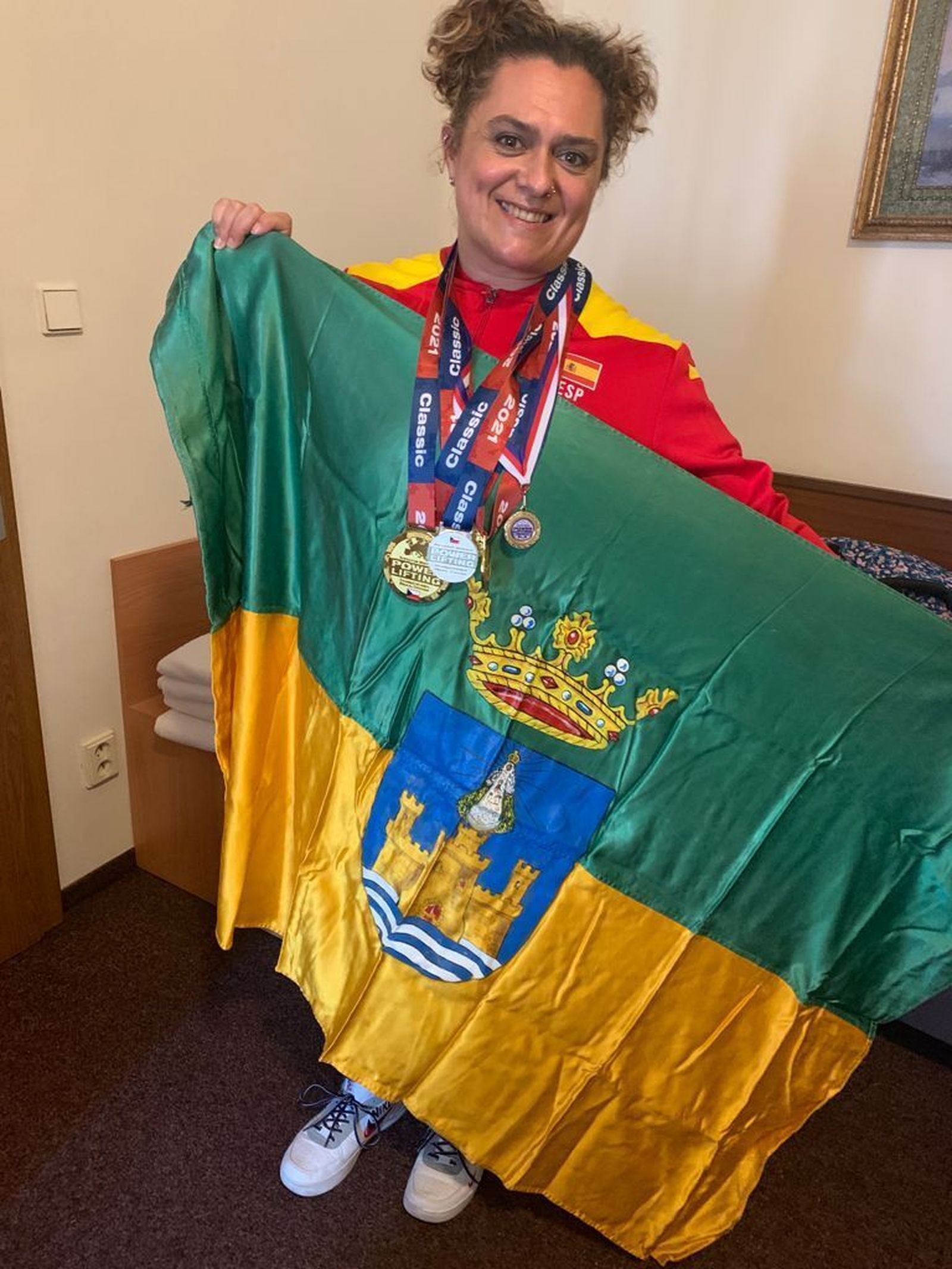 La portuense, con las medallas conseguidas y la bandera de El Puerto de Santa María.