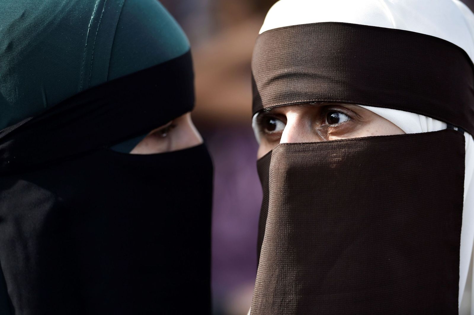 Dos mujeres cubren su rostro con un niqab.