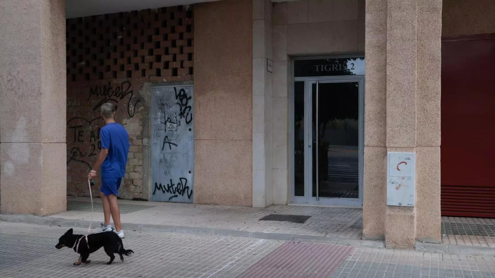 Un hombre pasea su perro por la puerta del número 2 de la calle Tigris, donde ocurrieron los hechos