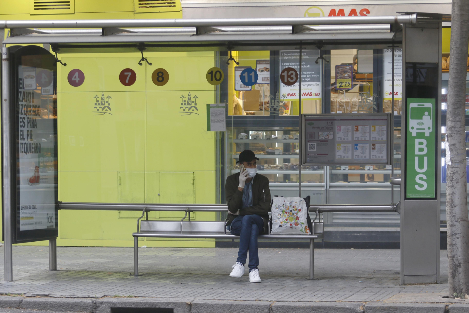 Un usuario del autobús aguarda la llegada del mismo en una parada.