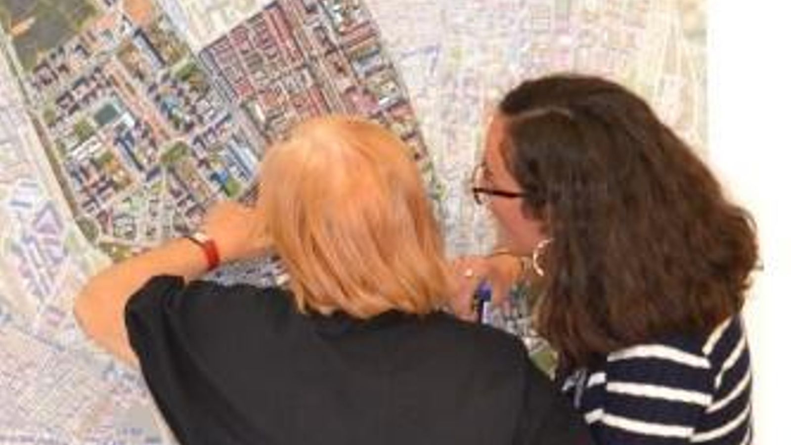 Vecinas consultando el mapa del distrito.