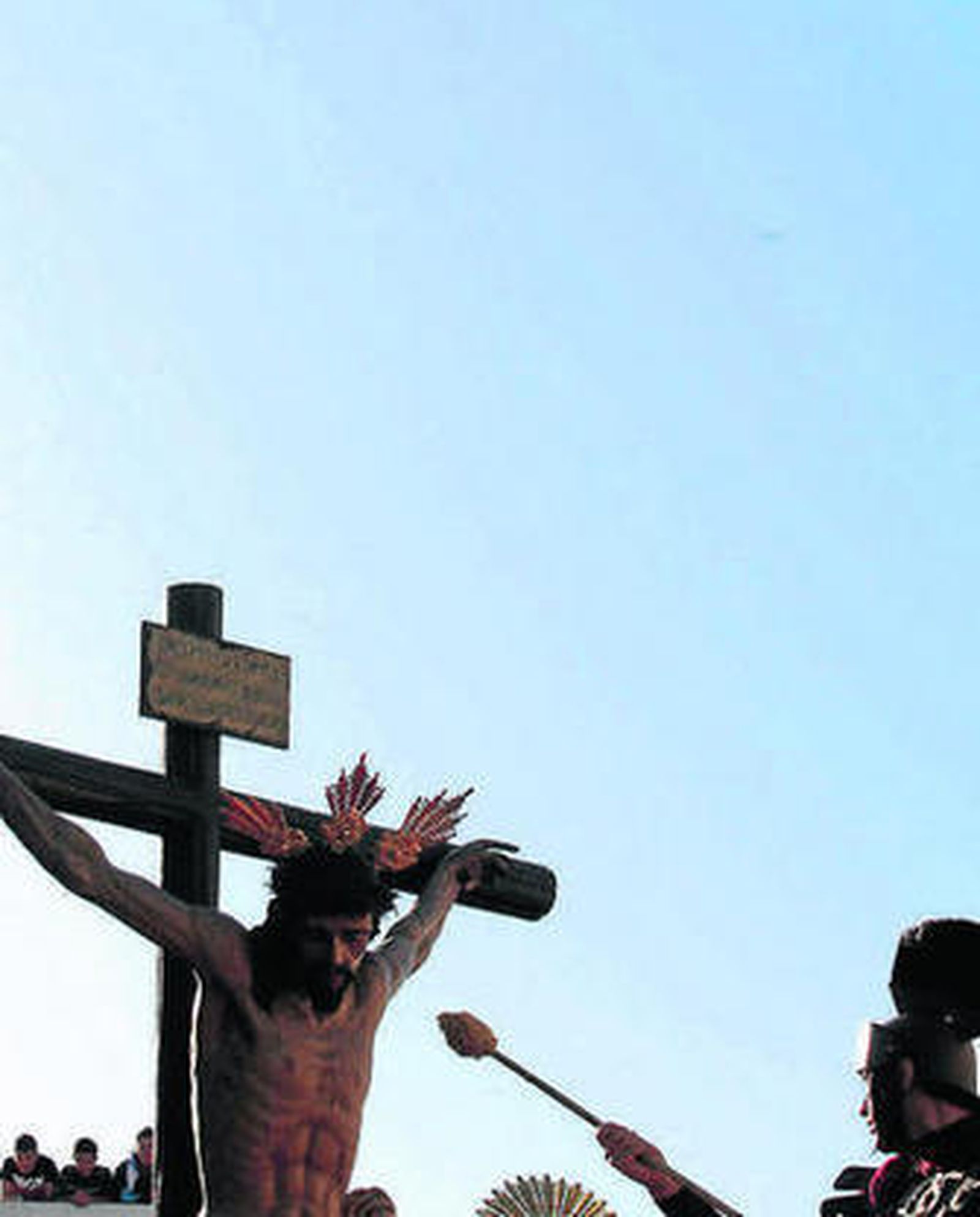 El romano acerca la esponja con vinagre al Cristo del Amor.