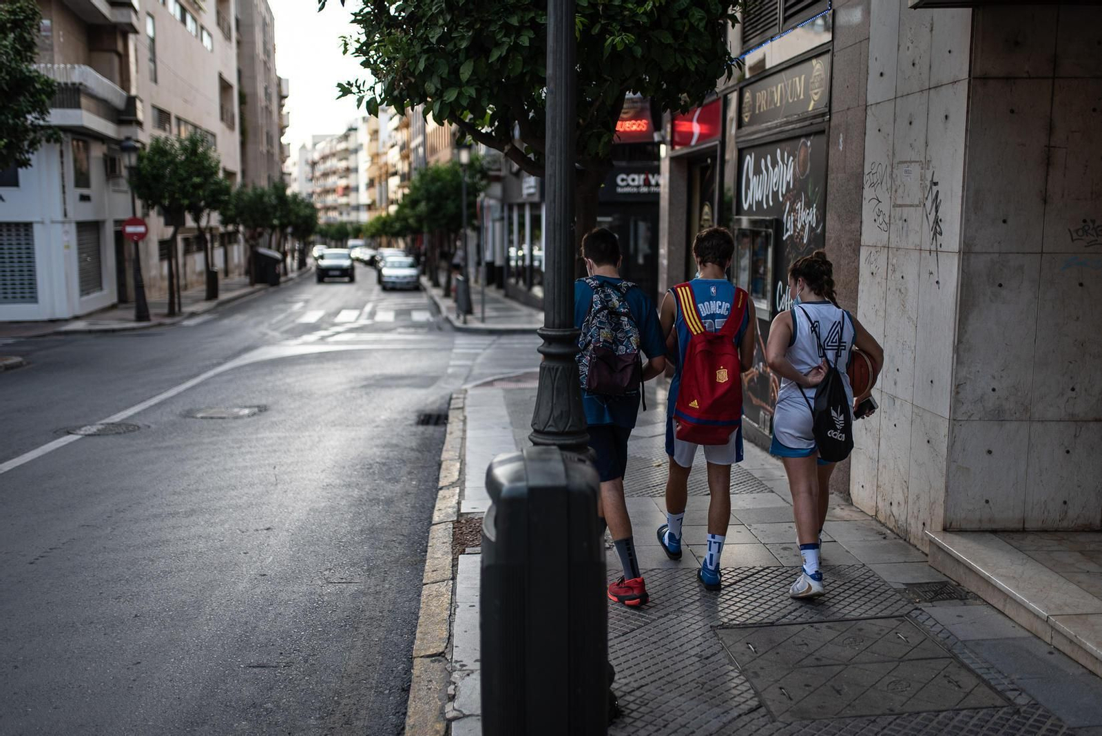 Tres jóvenes caminan por la calle Puerto de la capital onubense.