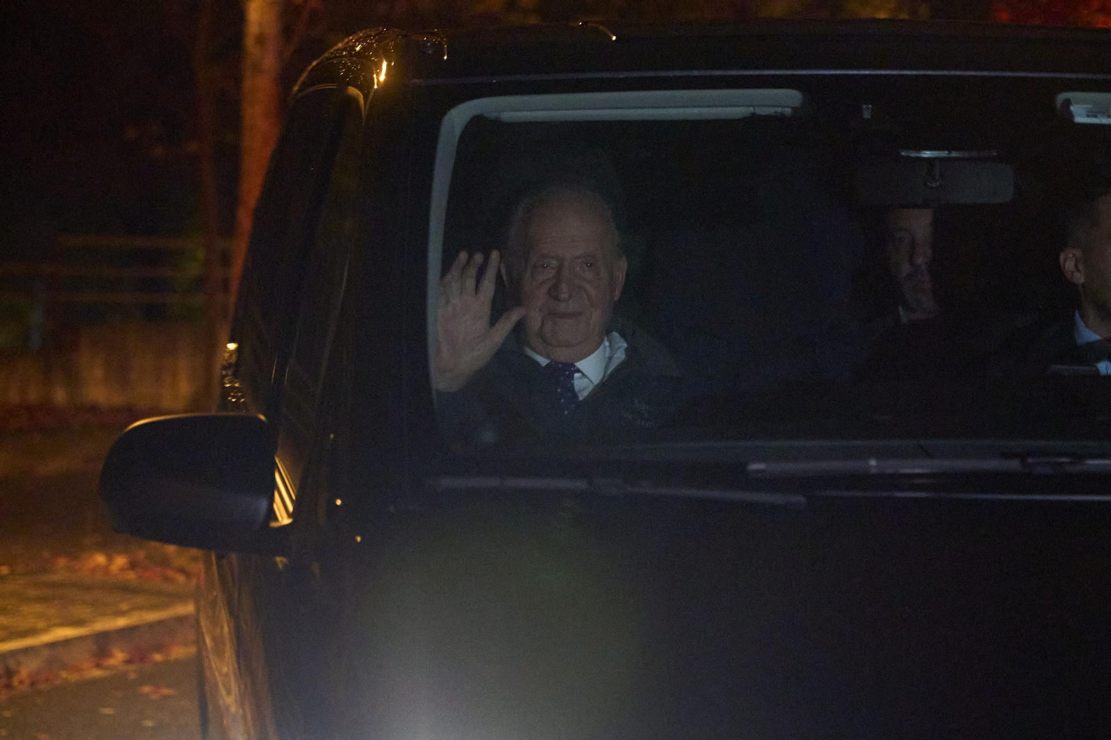 El rey Juan Carlos saluda desde el coche en Vitoria.