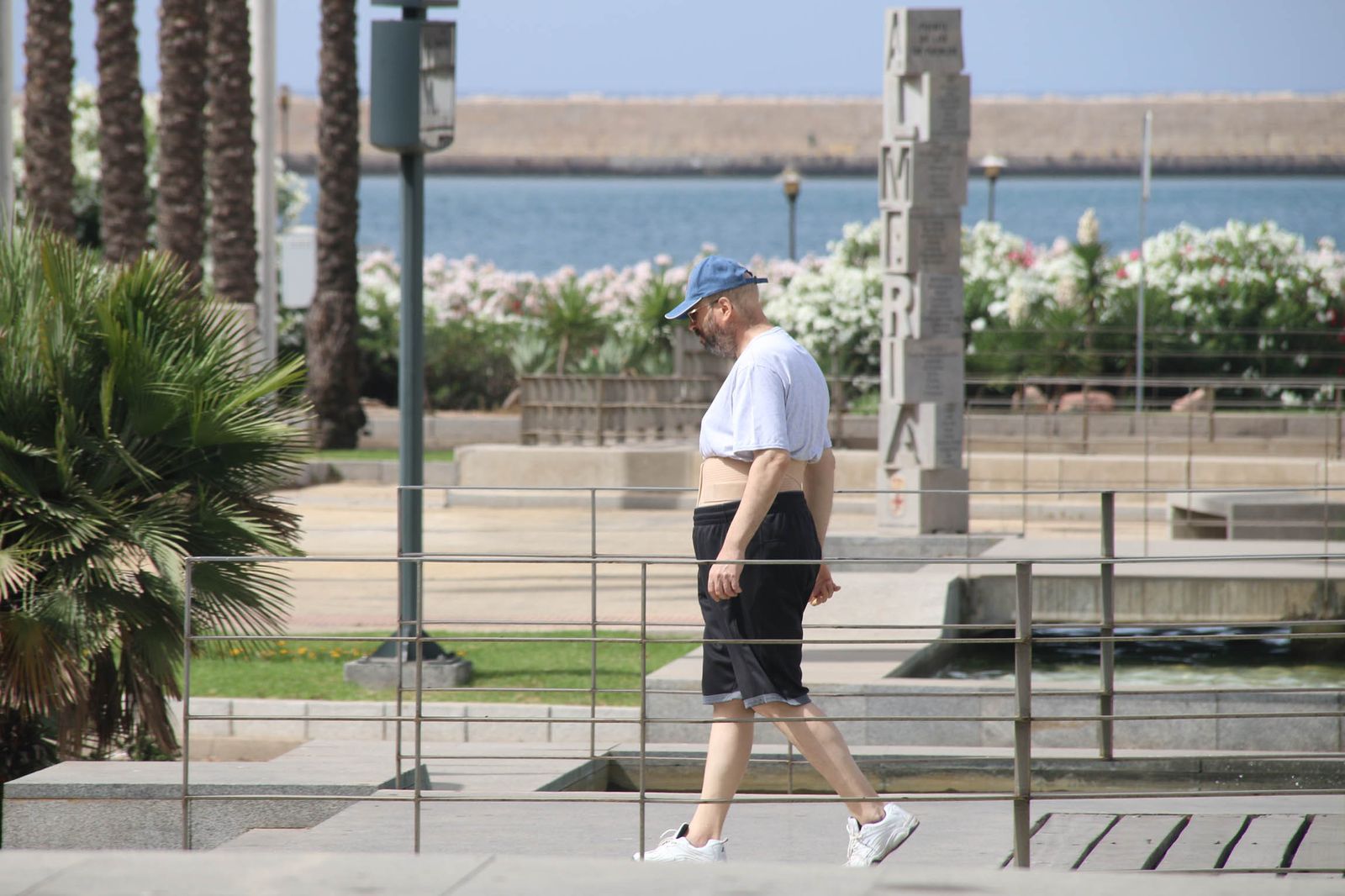 Dos personas mayores descansan en un banco y beben agua para soportar las altas temperaturas.