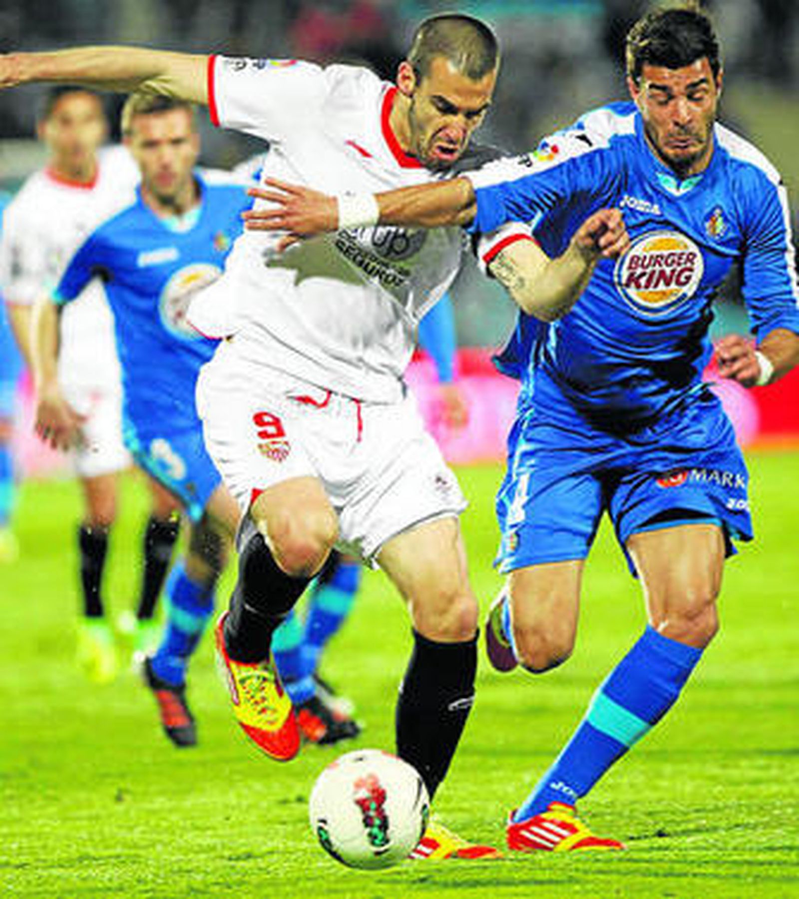 Negredo conduce el balón con la oposición de Miguel Torres.