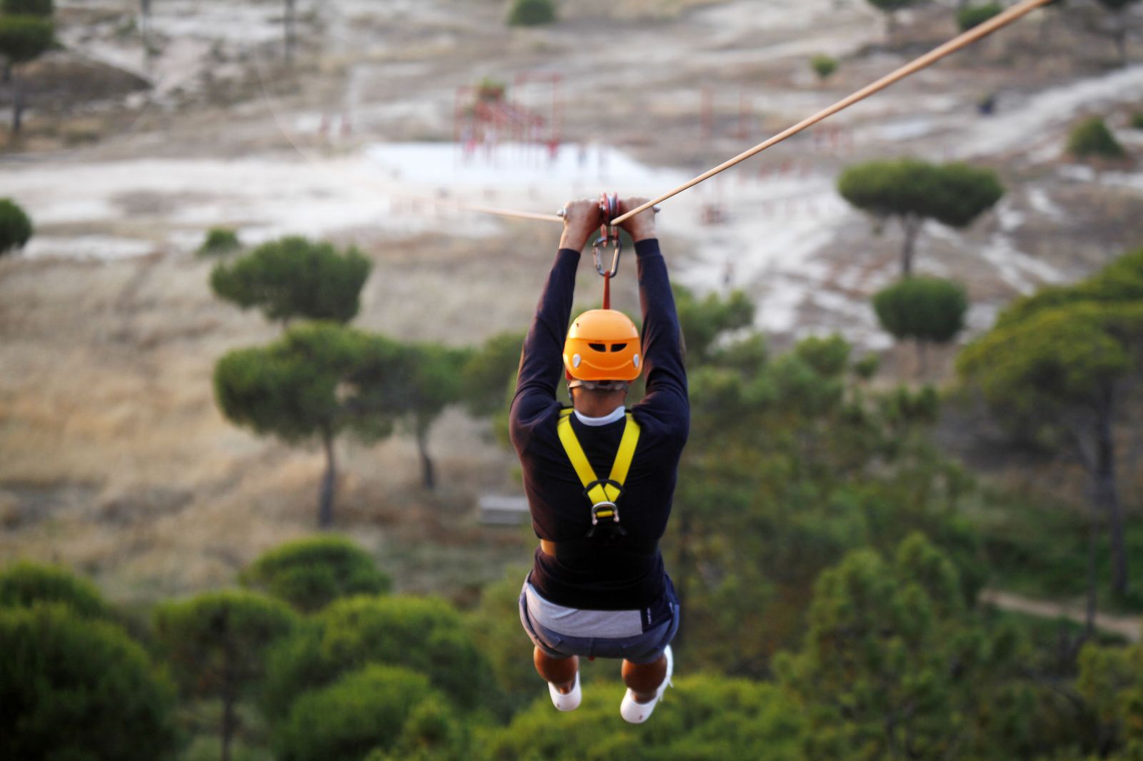 Un usuario disfruta de la experiencia de descender por la tirolina urbana de más largo recorrido de Europa.