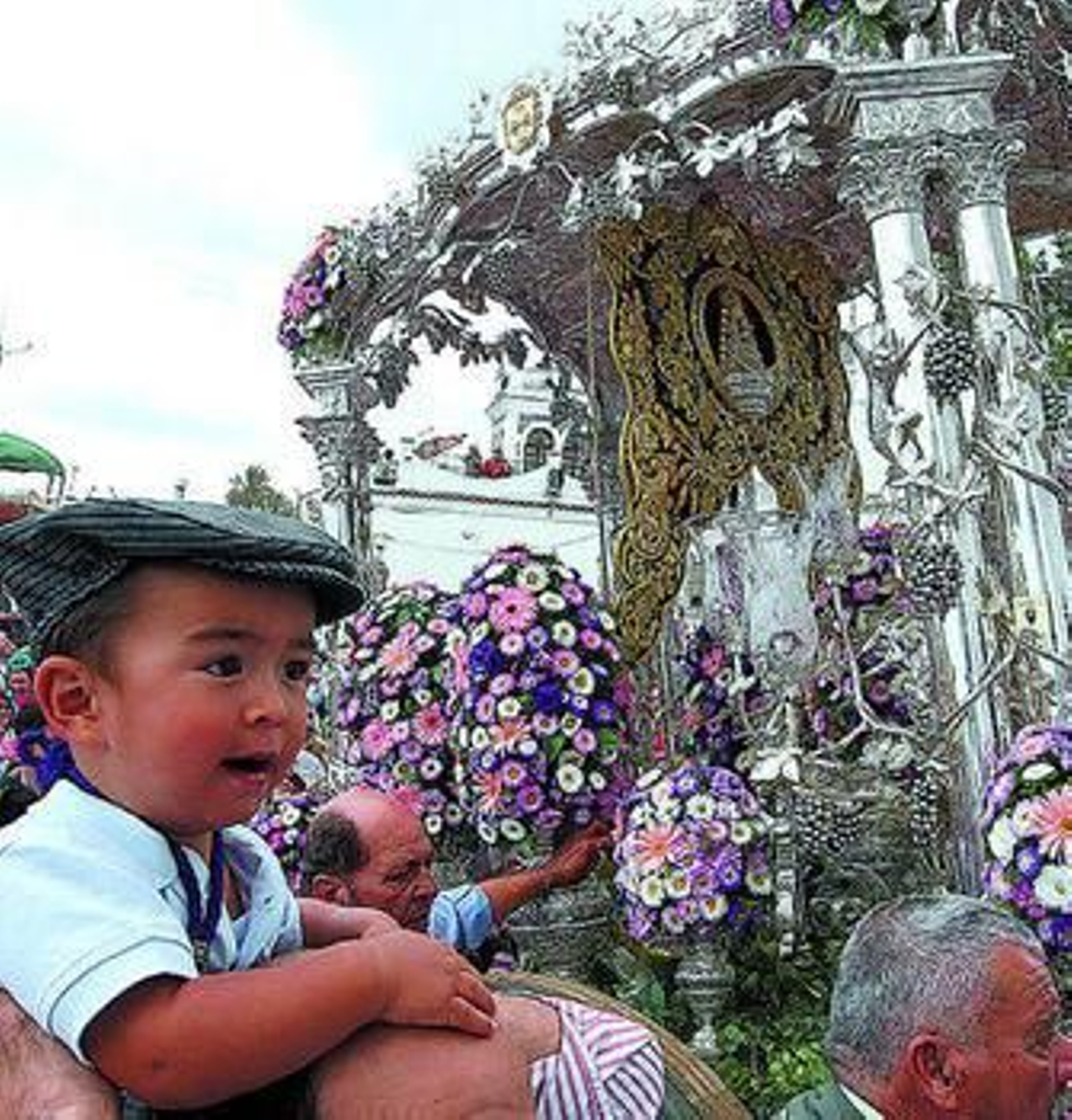 Un niño es acercado al Simpecado de Jerez en el embarque de 2008.