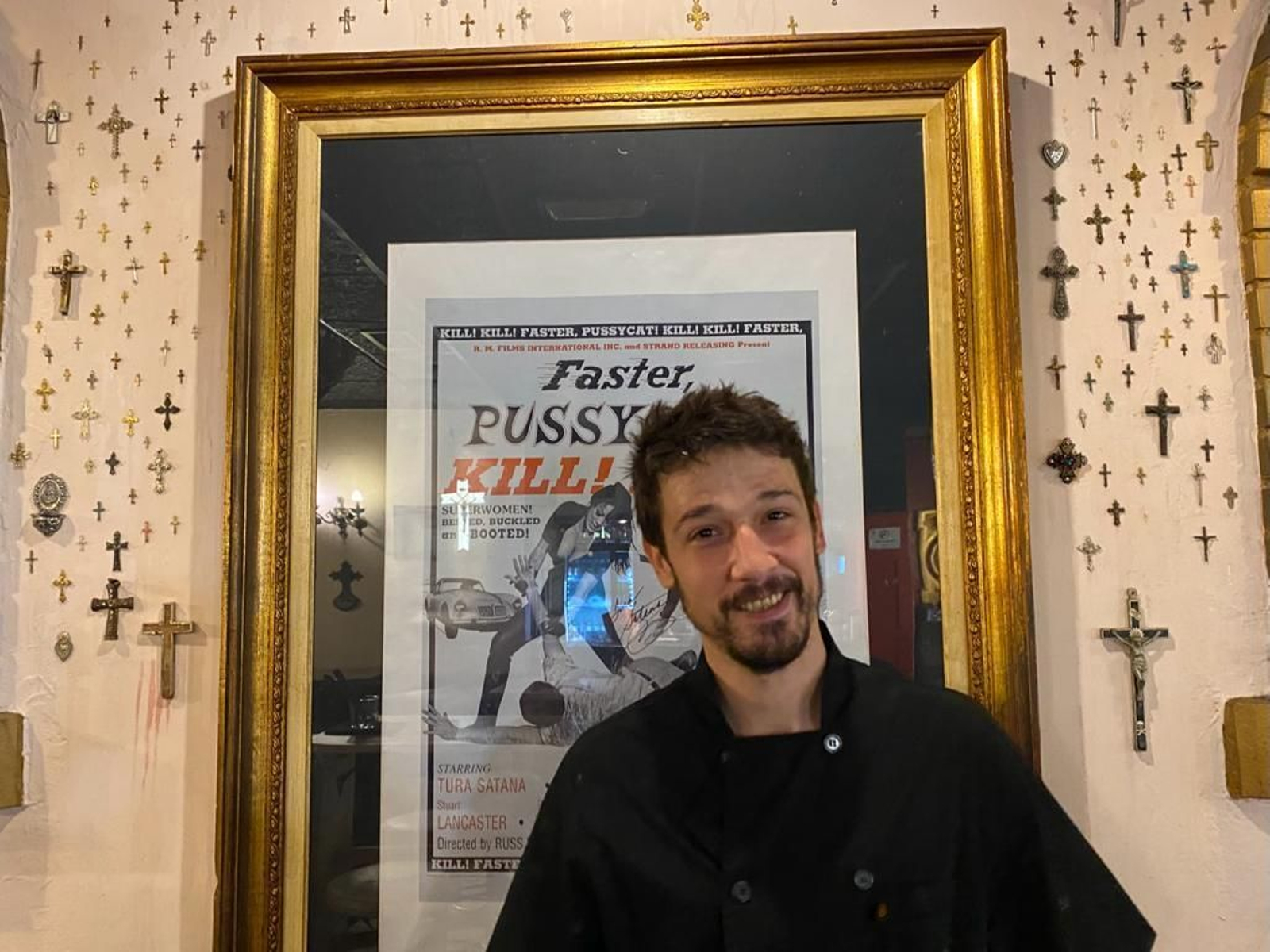 Pablo Asensio, uno de los dueños de la Croqueteria, junto al cartel de la película de Tura Santana que inspiró el concepto 'La Mala'