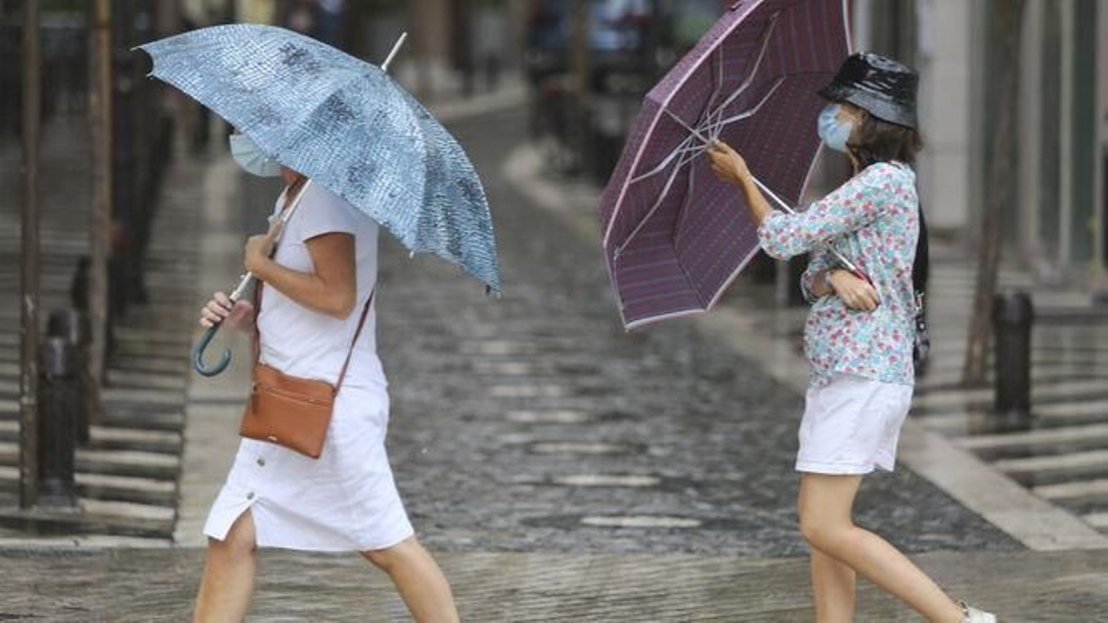 Dos personas con paraguas en Málaga capital.