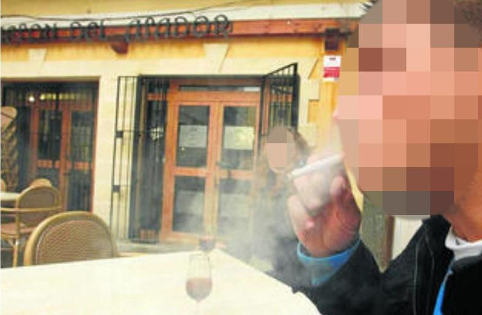 Un fumador con una copa de Jerez sentado en una terraza de un bar del centro.