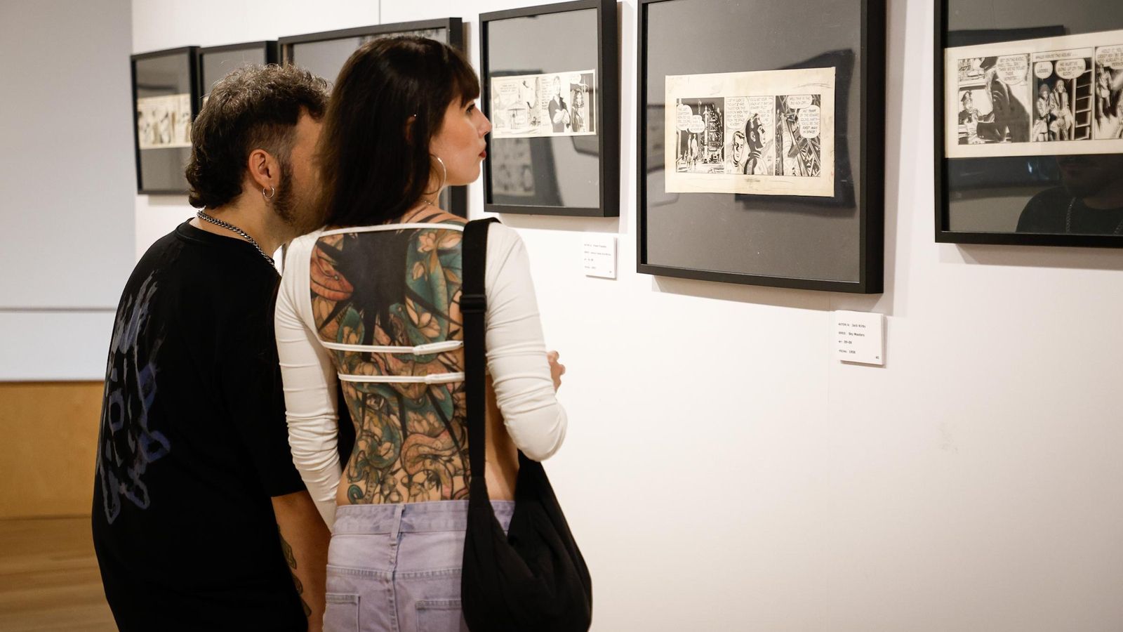 Una pareja observa varias obras de la exposición.
