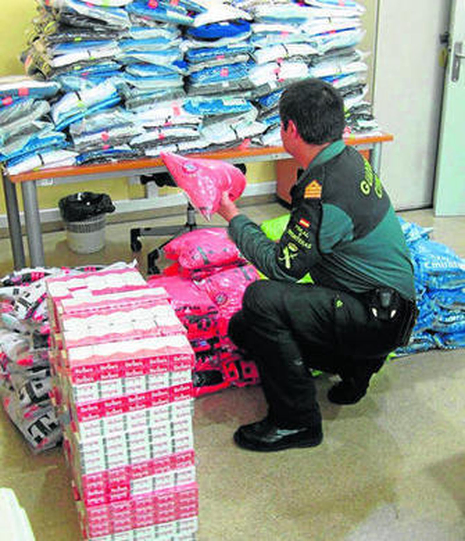 Un agente de la Guardia Civil con parte de los materiales incautados.