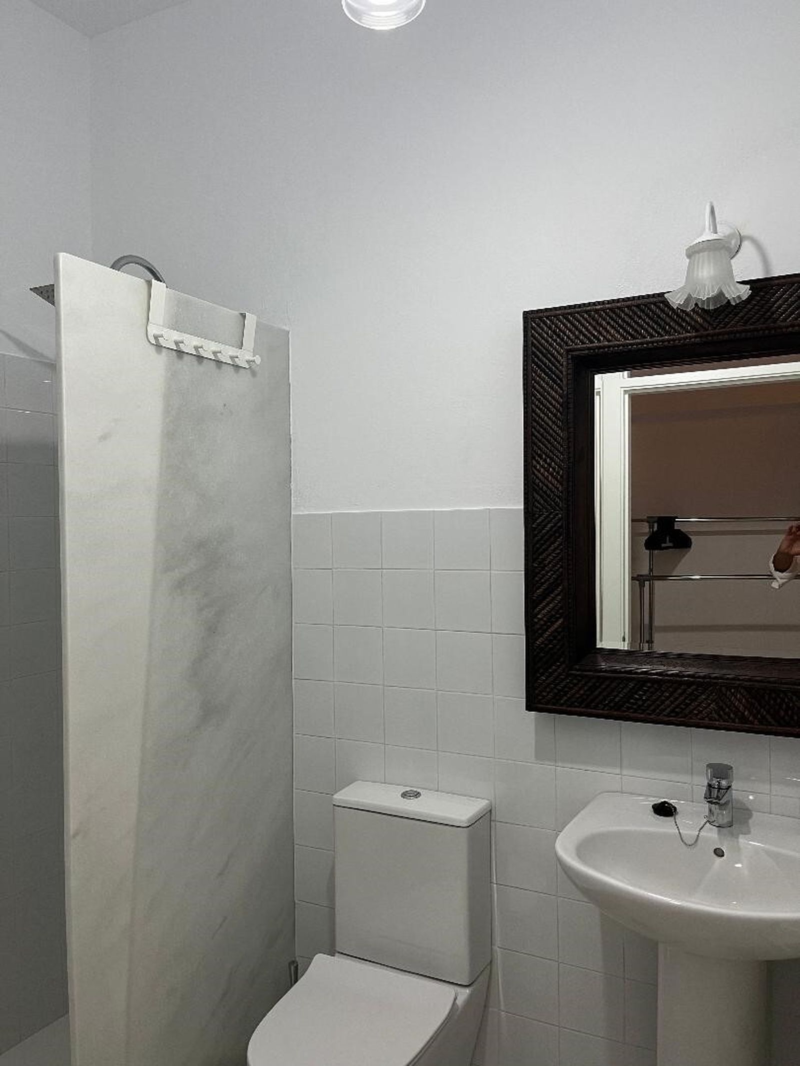 Cuarto de baño, con mampara de mármol en la ducha.