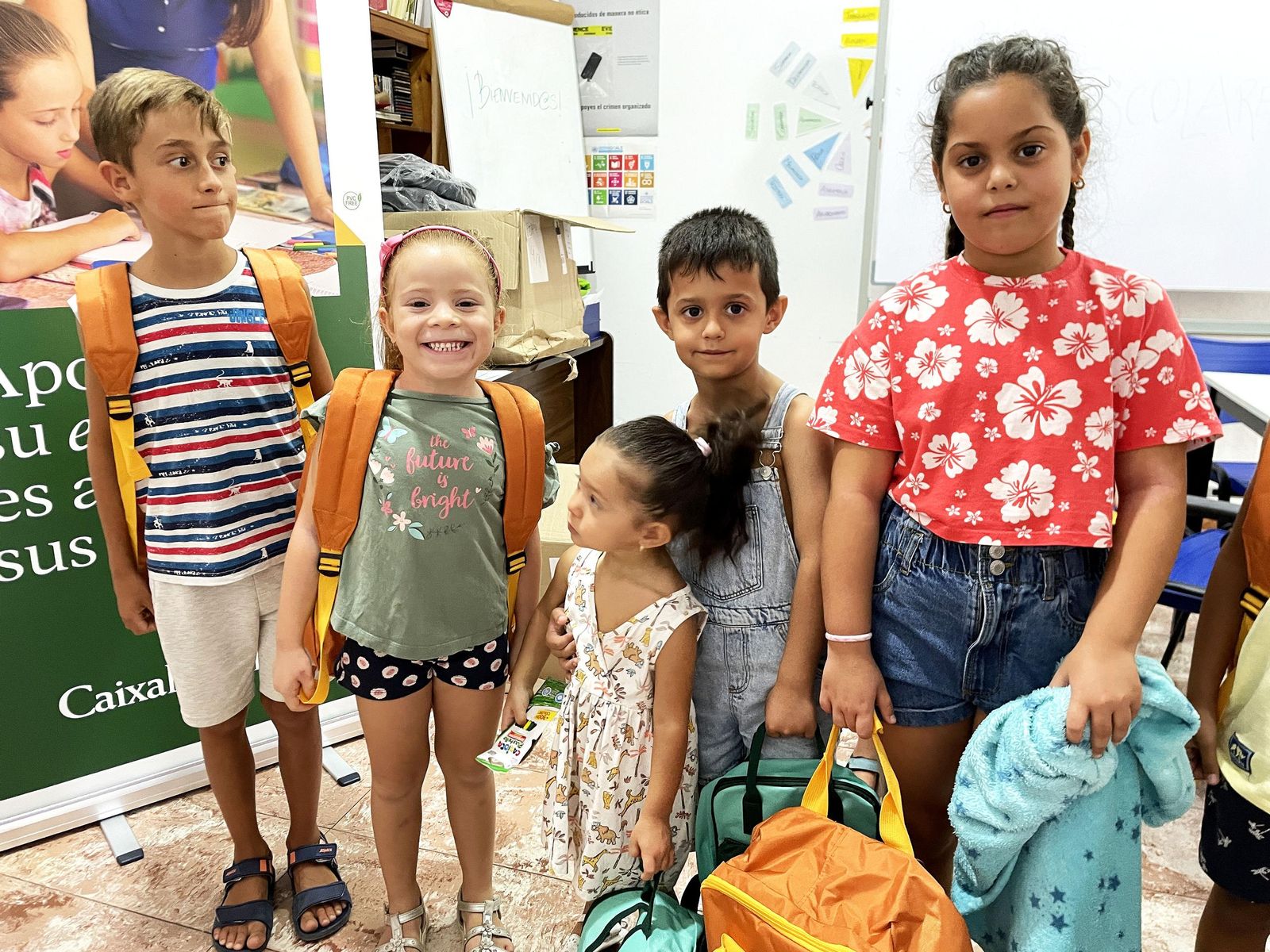 Niños con las mochilas repartidas por la Fundación La Caixa.