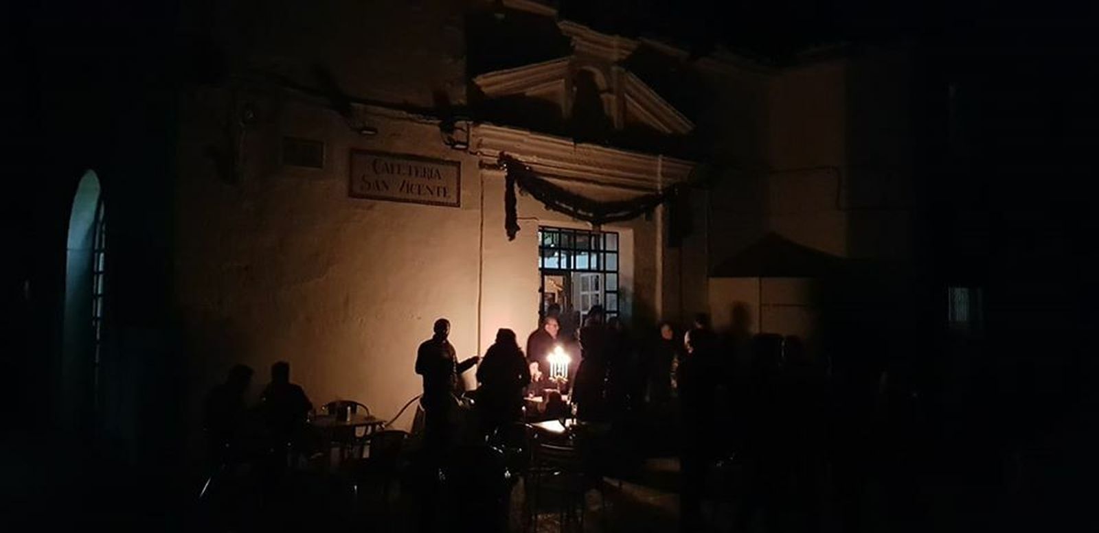 Vecinos alumbrados  con un candelabro durante el apagón, coincidiendo con el paso de la Cabaltaga de Reyes Magos en Guadalcanal.