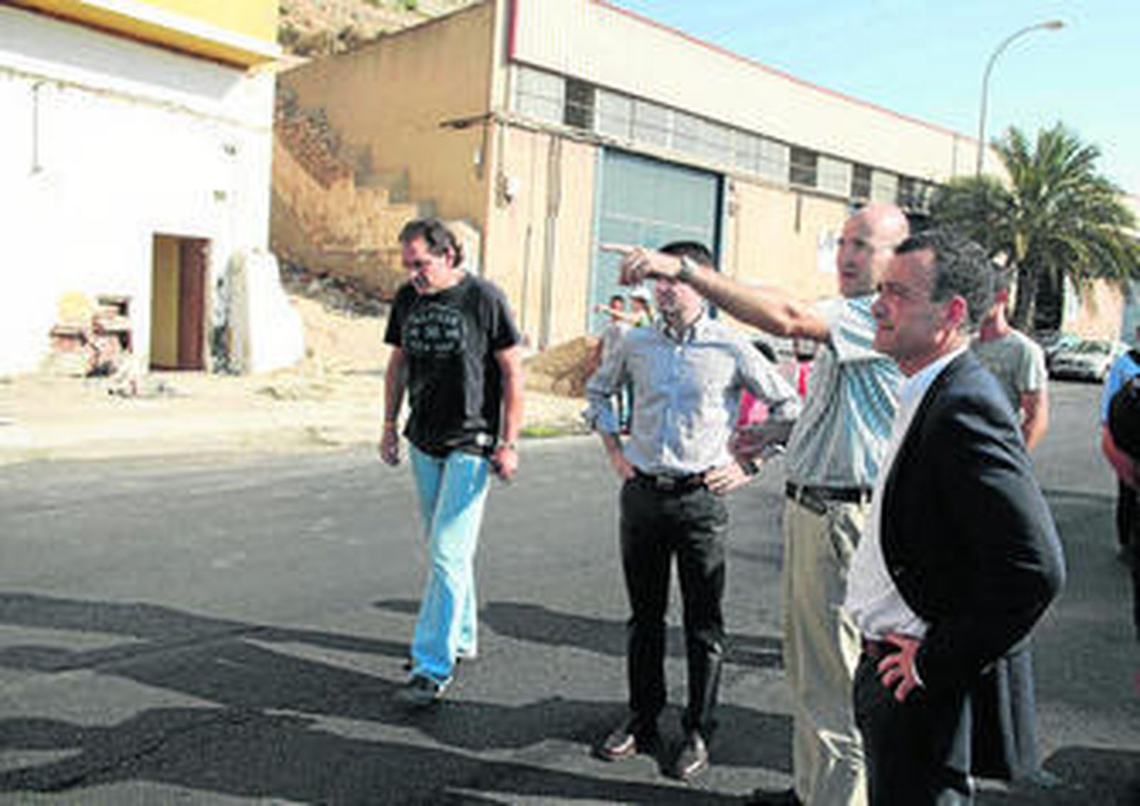 El concejal de Urbanismo, Pablo Venzal. Al fondo, con las puertas azules, las naves a derribar.