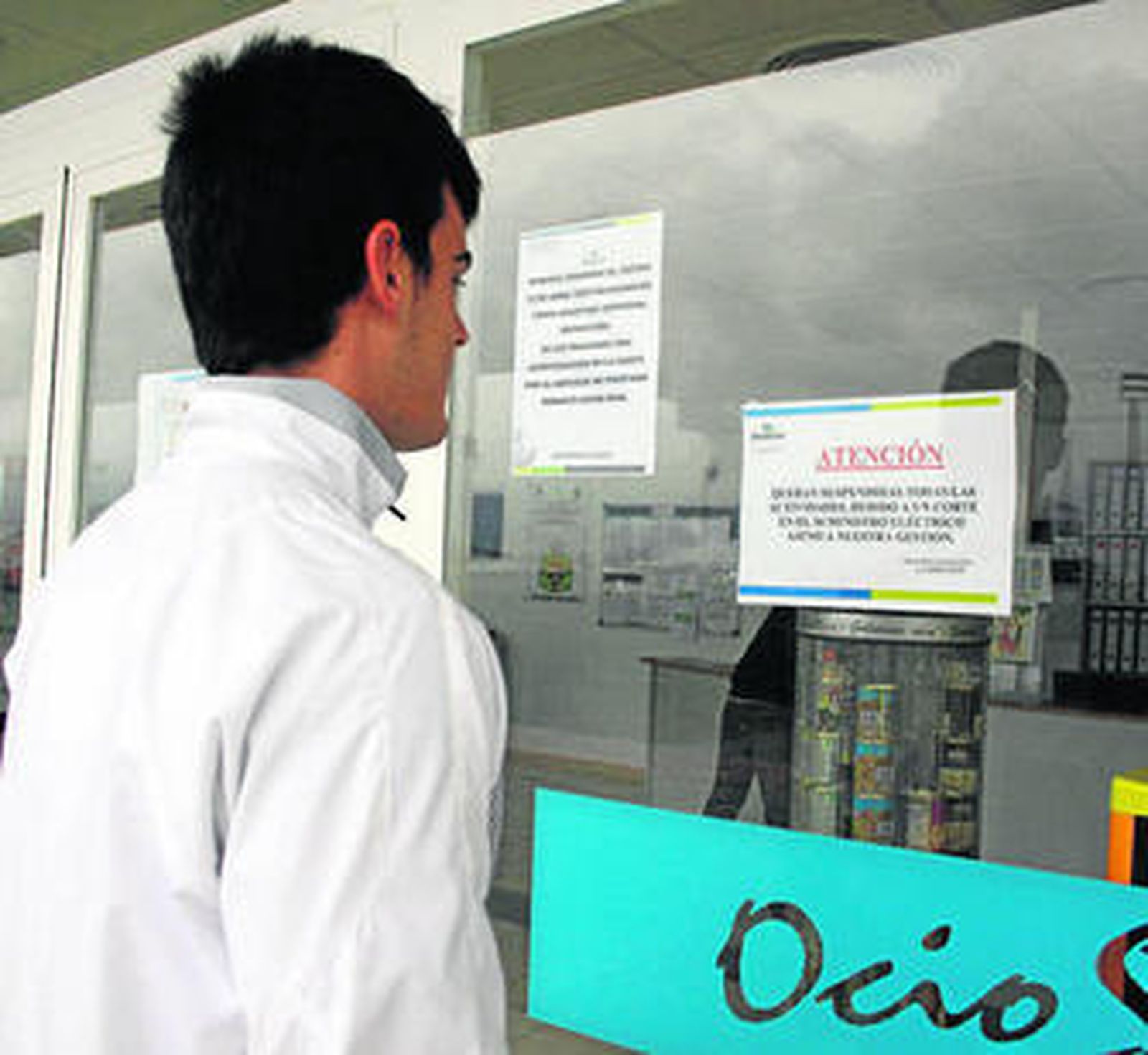 Un usuario lee el cartel que informa del cese temporal de las actividades en la piscina, ayer.