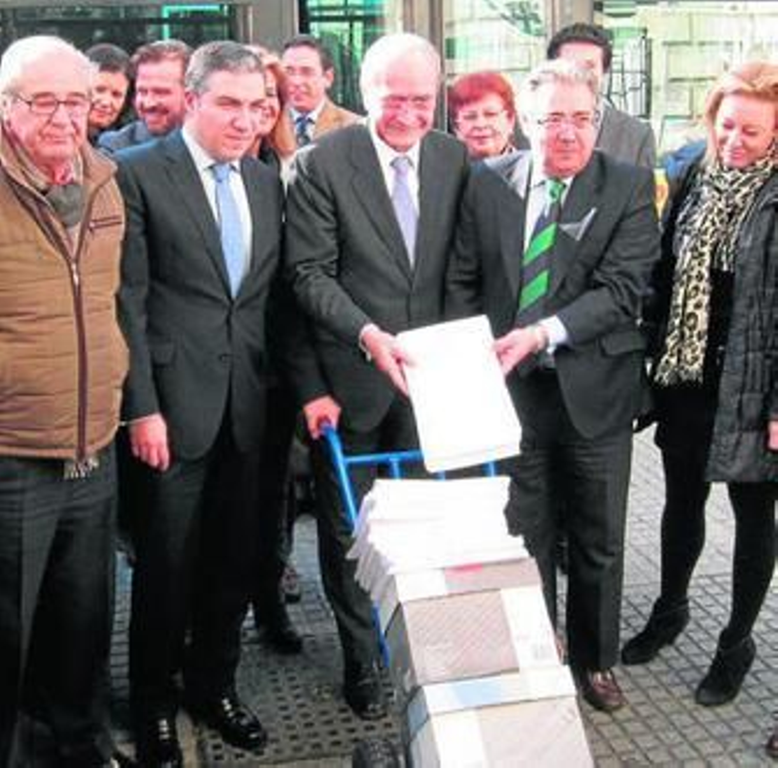 Bendodo, De la Torre y Zoido trasladan las firmas contra el Metro en superficie en una carretilla.