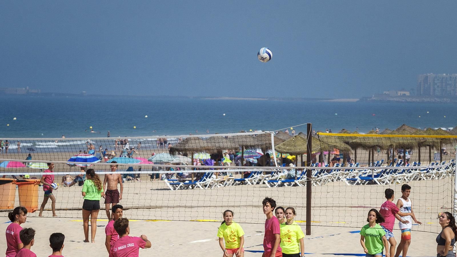 Un grupo de jóvenes juega al vóley playa.