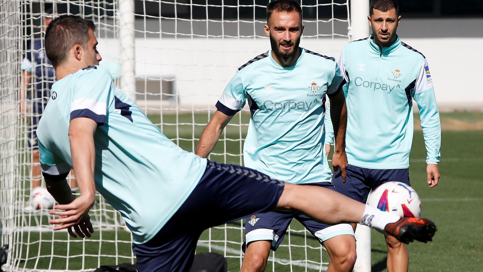 Sokratis golpea la pelota en un entrenamiento ante la mirada de Pezzella y Guido Rodríguez