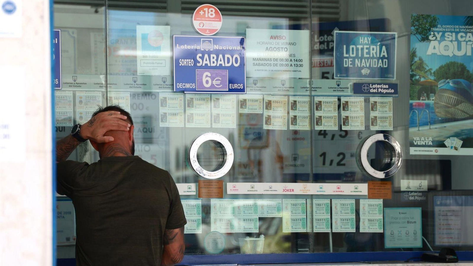 Una persona se dispone a adquierir un boleto en una Administración de Loterias, en el centro de Sevilla.