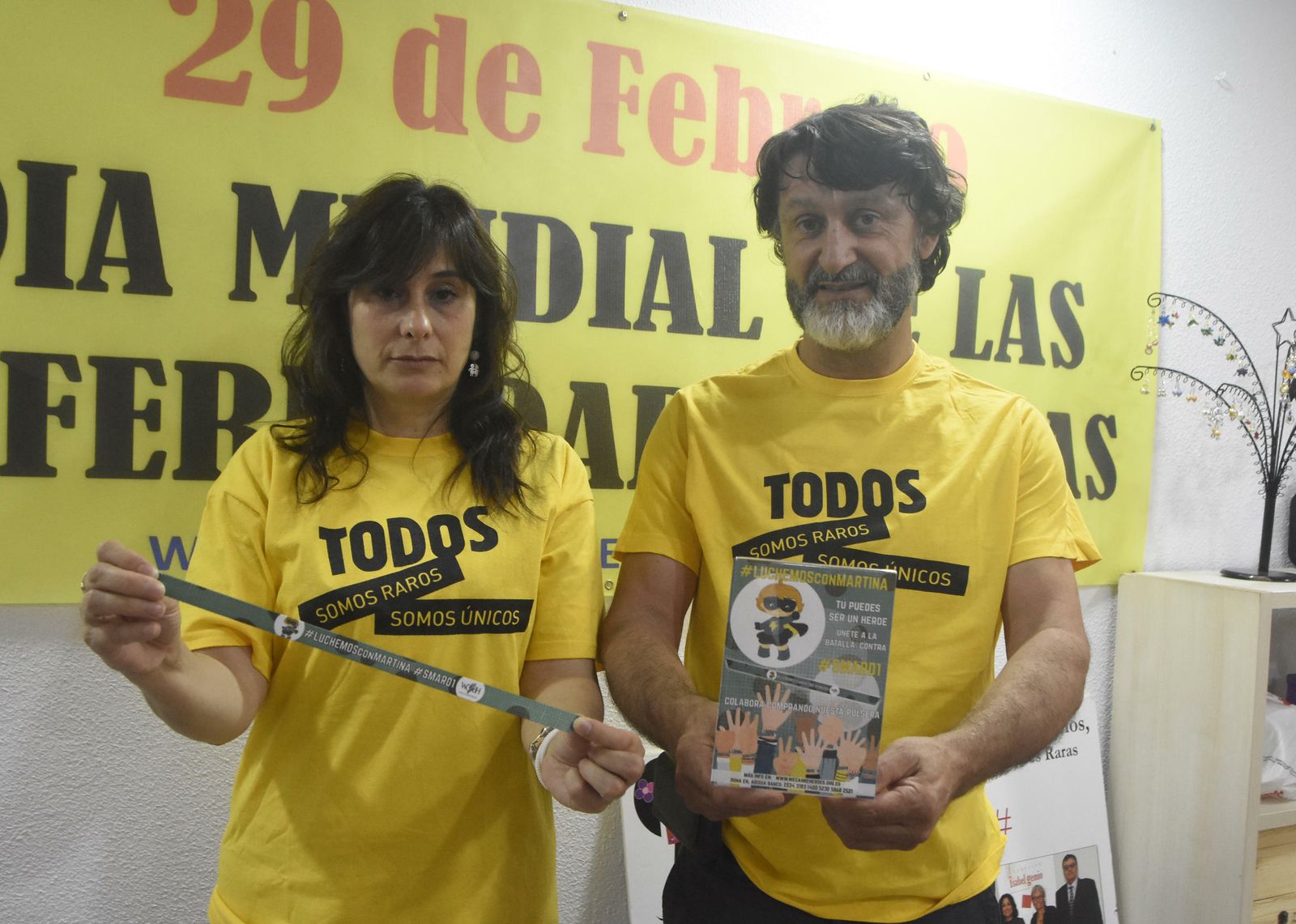 Rosa García y David González, ambos de Remps, enseñan la pulsera para ayudar a Martina.