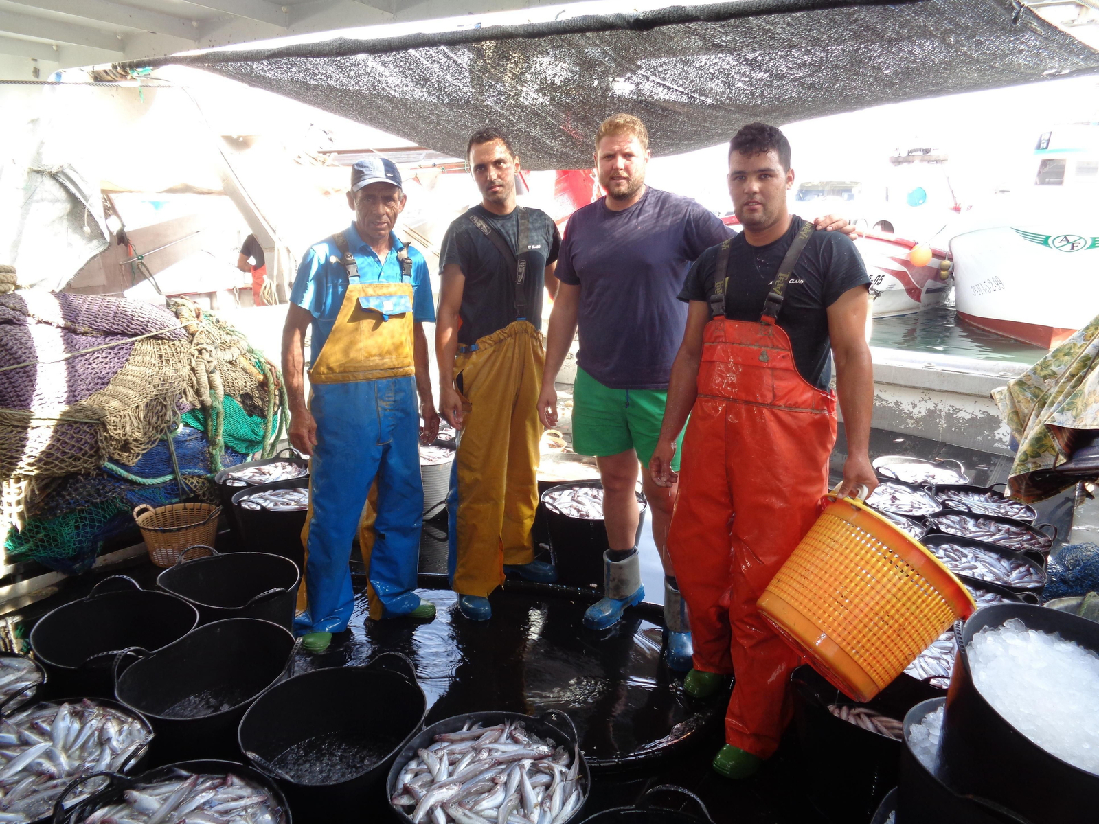 Pescadores preparan a bordo del barco las capturas del día para su venta en la lonja del puerto de Caleta de Vélez.