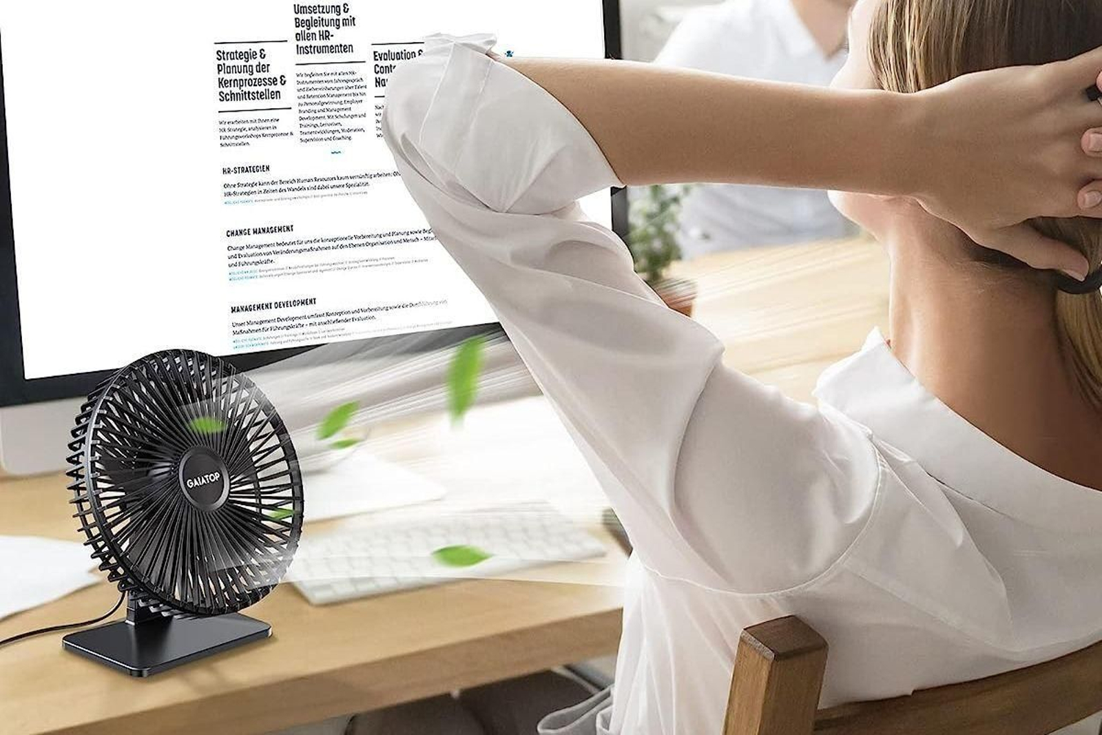 Una persona, combatiendo el calor con un ventilador de escritorio. Una persona, combatiendo el calor con un ventilador de escritorio.