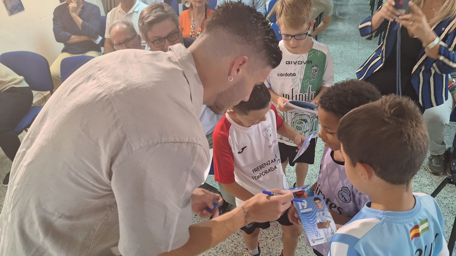 Roberto Fernández firma autógrafos a varios niños en Puente Genil.