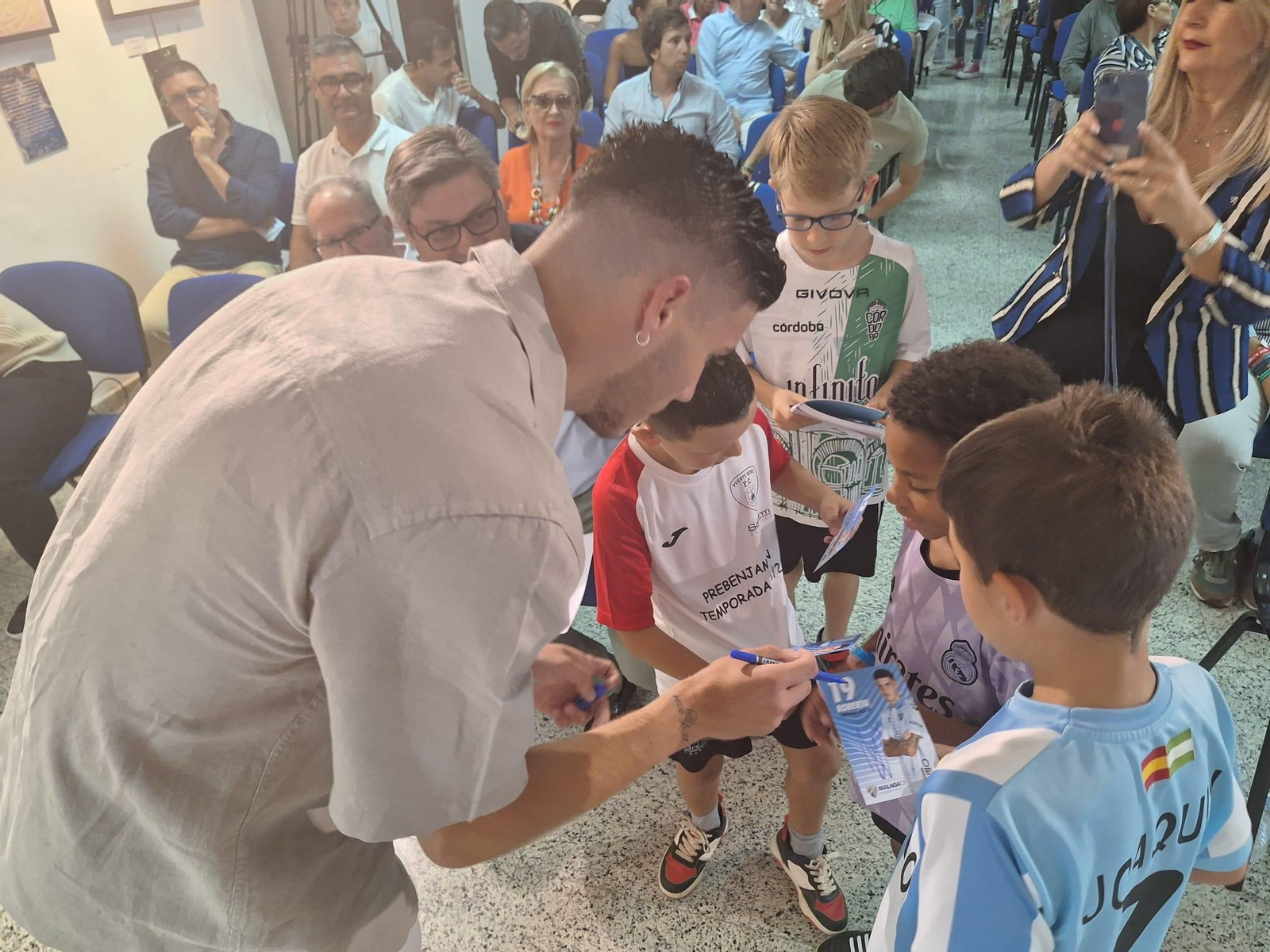 Roberto Fernández firma autógrafos a varios niños en Puente Genil.
