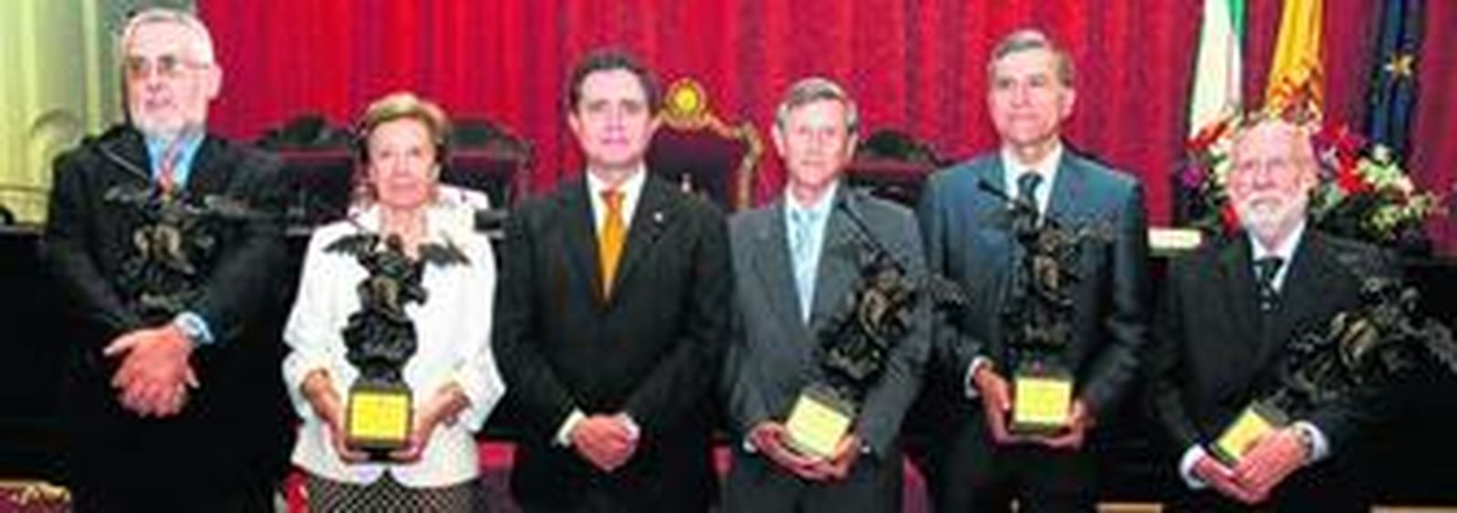 El rector de la Universidad de Sevilla, Joaquín Luque (en el centro), con los catedráticos galardonados con los Premios Fama de 2011: Bartolomé Clavero, Pilar León-Castro; José Luis Huertas Díaz, Antonio Gómez Expósito y Alberto Machado, con las réplicas en bronce de la representación alegórica de la Fama, mensajera alada de Zeus y Júpiter, símbolo de la Hispalense.