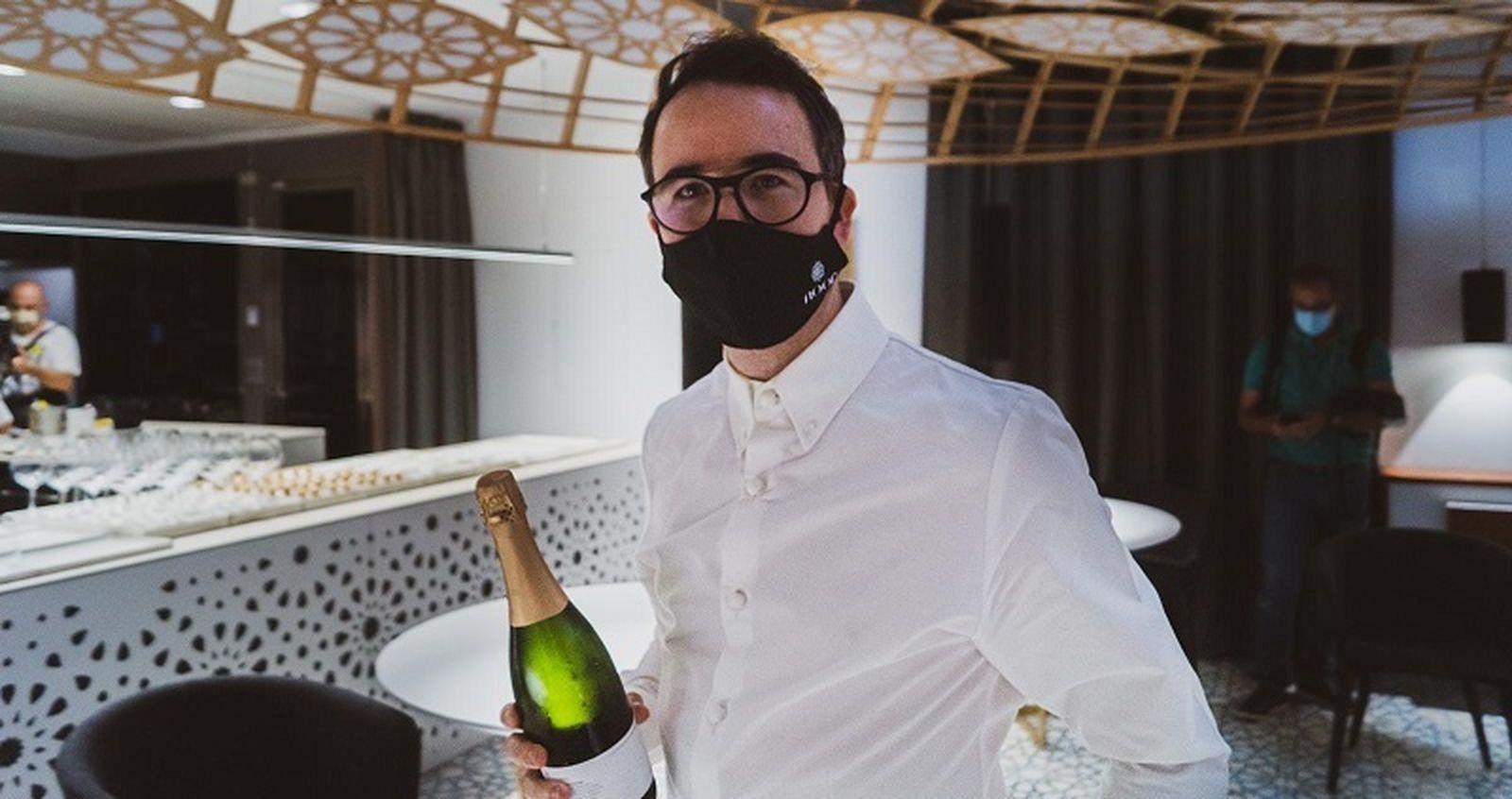 El chef Paco Morales sostiene una botella de Robles Brut Nature.