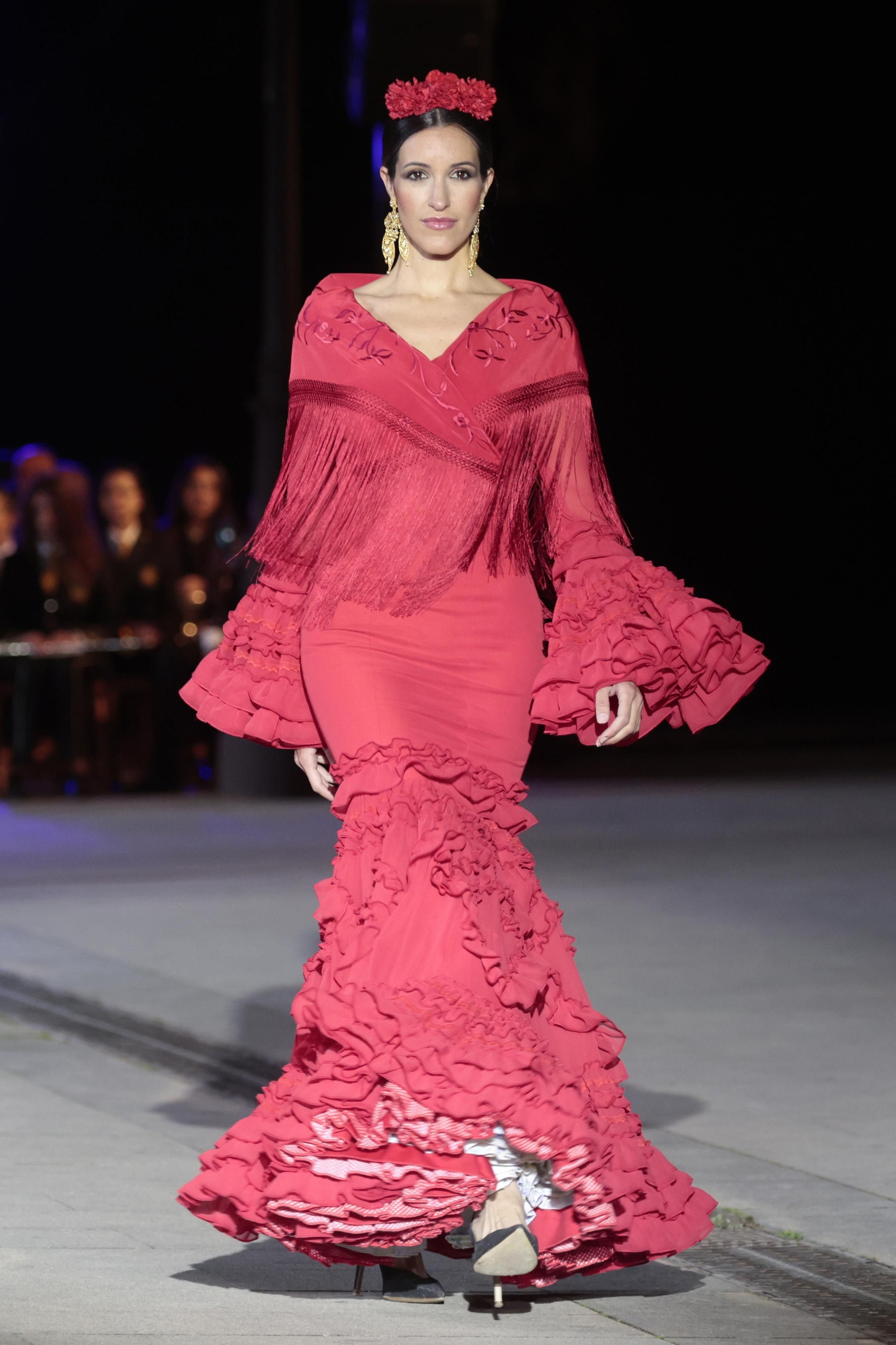 Un traje de flamenca rojo combinado con un mantoncillo rojo visto en el desfile 'Andalucía es flamenca'. Un traje de flamenca rojo combinado con un mantoncillo rojo visto en el desfile 'Andalucía es flamenca'.