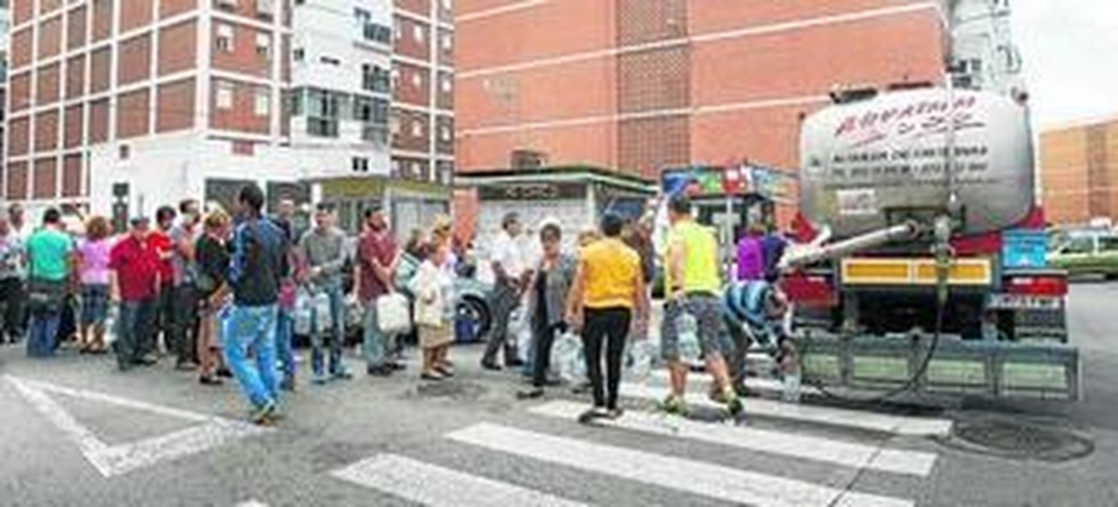Los vecinos hacen cola para recoger agua de una de las cubas en Loreto en la mañana de ayer.