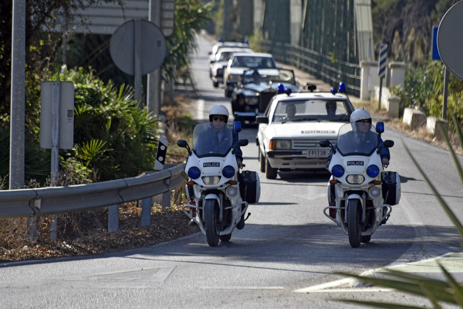El Rolls Royce escoltado por coches policiales australianos cruza el puente de hierro de Guadiaro.