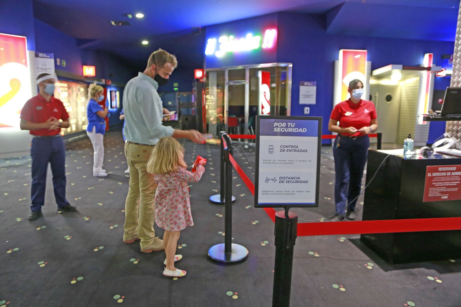 Un padre y su hija acceden a los cines con la entrada electrónica, en la tarde de este viernes.