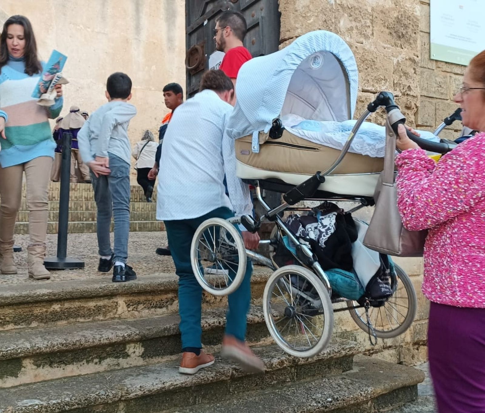 Una pareja, accediendo al castillo con una silla de bebé.