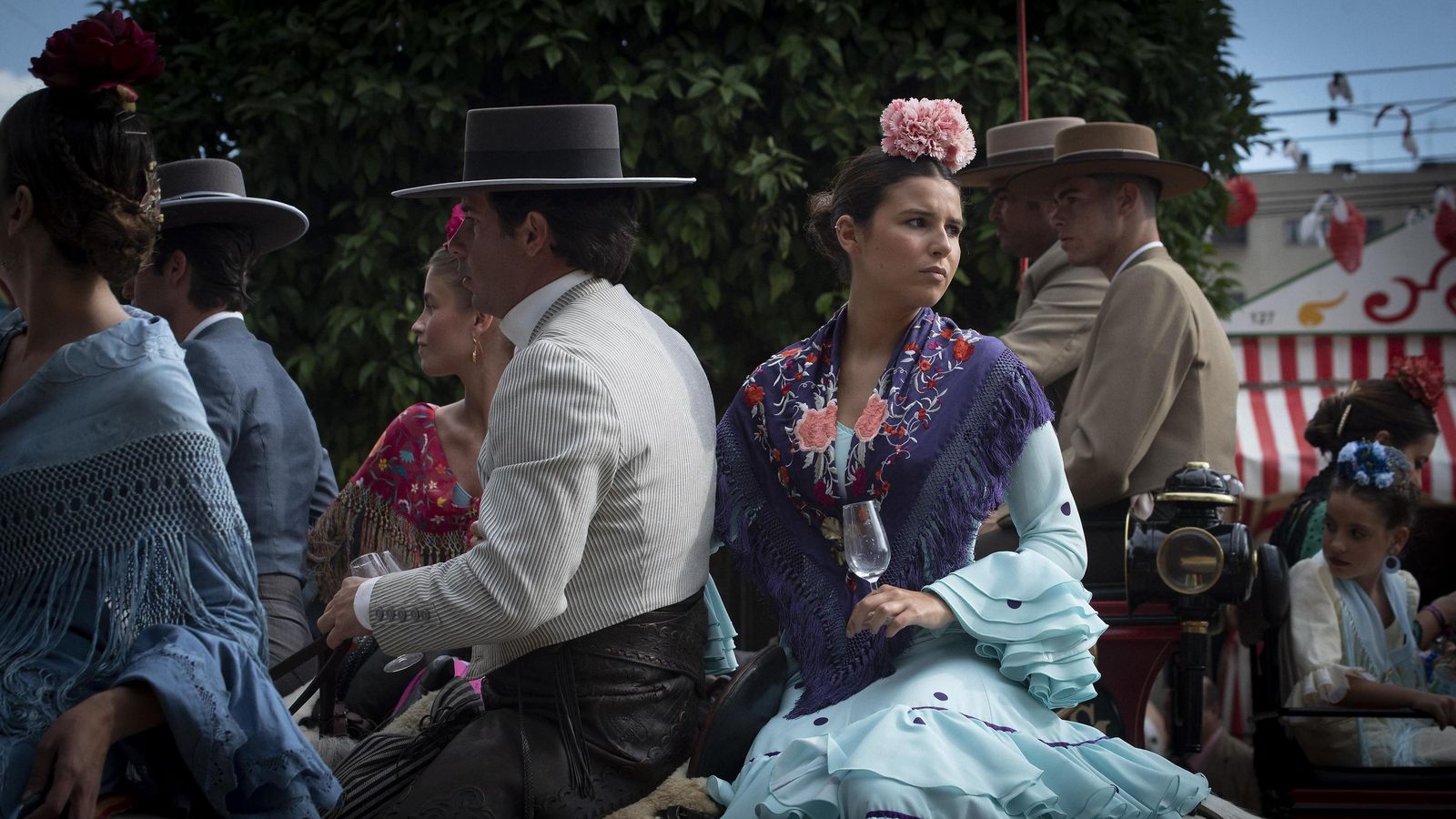 Un caballista y su pareja, vestida de flamenca. Ambos con catavinos en las manos.