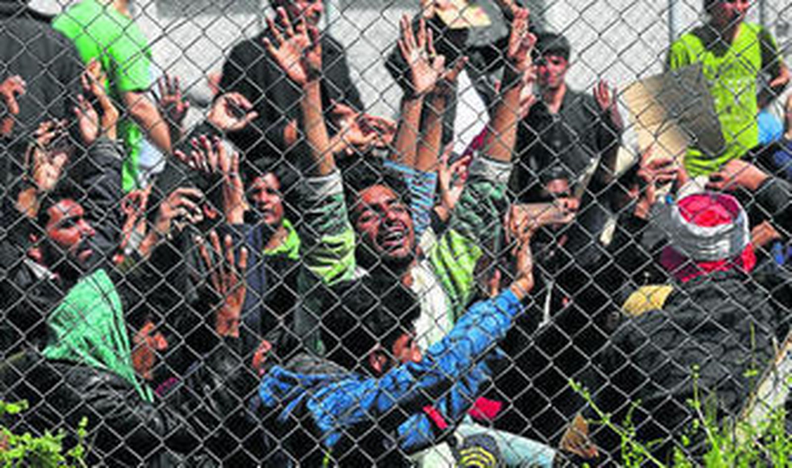 Inmigrantes afganos y paquistaníes protestan ayer contra su deportación en el centro de detención de Moria.