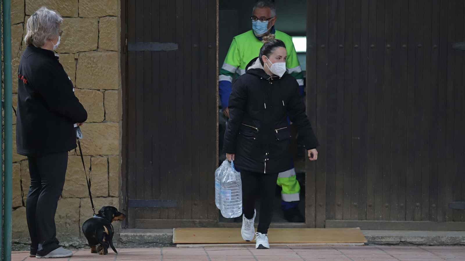 Una mujer recoge dos garrafas de agua en La Alcaidesa, el pasado miércoles.