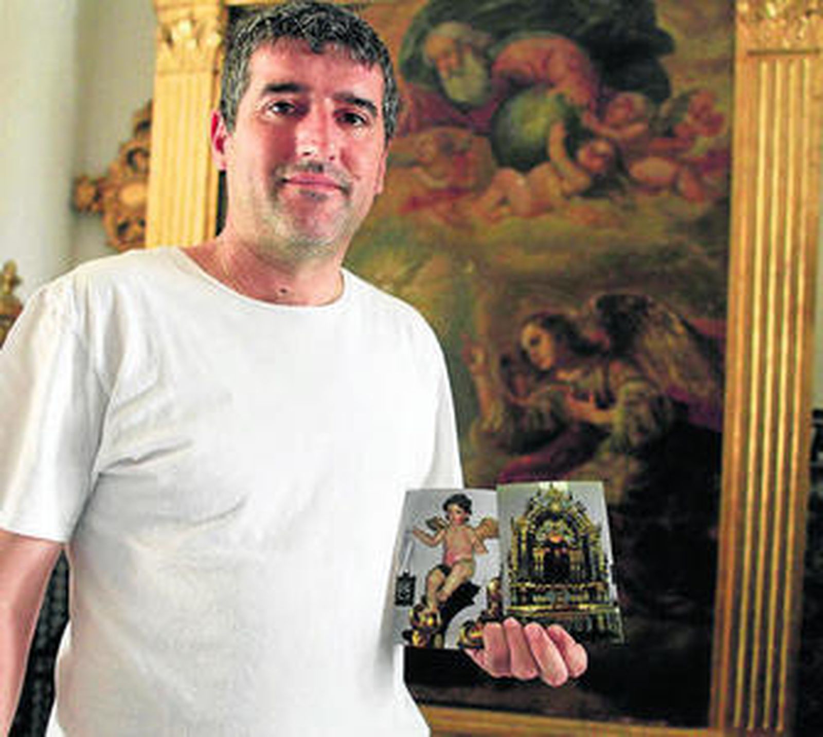 Juan Carlos Sedeño con las fotos del retablo de la Virgen del Carmen.