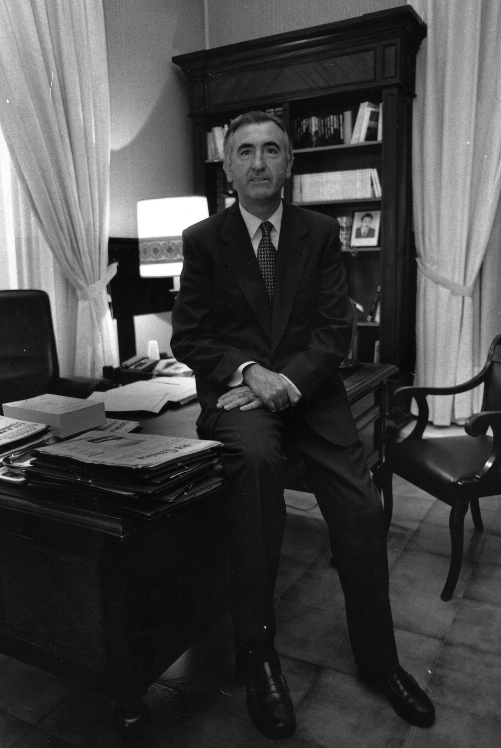 Juan Megino, fundador de GIAL, sentado sobre la mesa del alcalde, en 1997 cuando era del PP