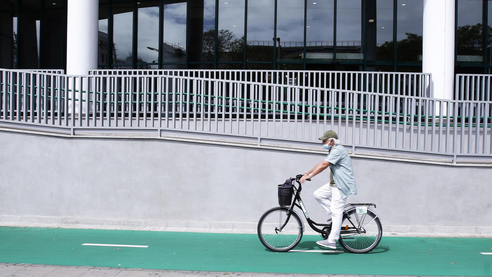 Vista de la barandilla de la rampa lateral, de las cristaleras de la estación y del carril bici recién pintado.