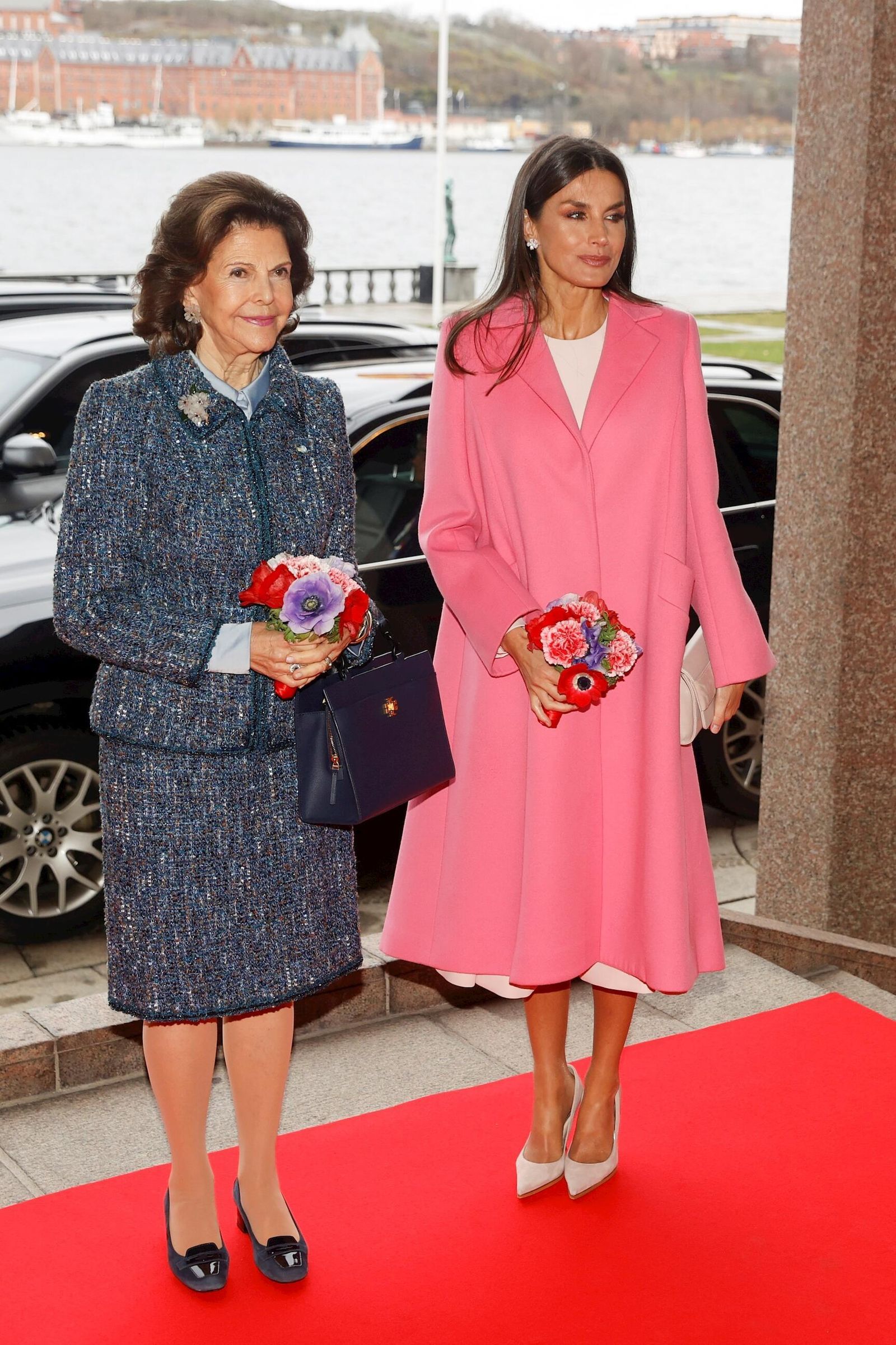 Doña Letizia, con abrigo rosa chicle de Carolina Herrera, en compañía de la reina Silvia.