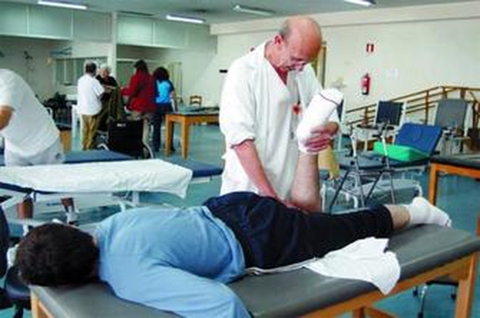 Un fisioterapeuta trata a un paciente.