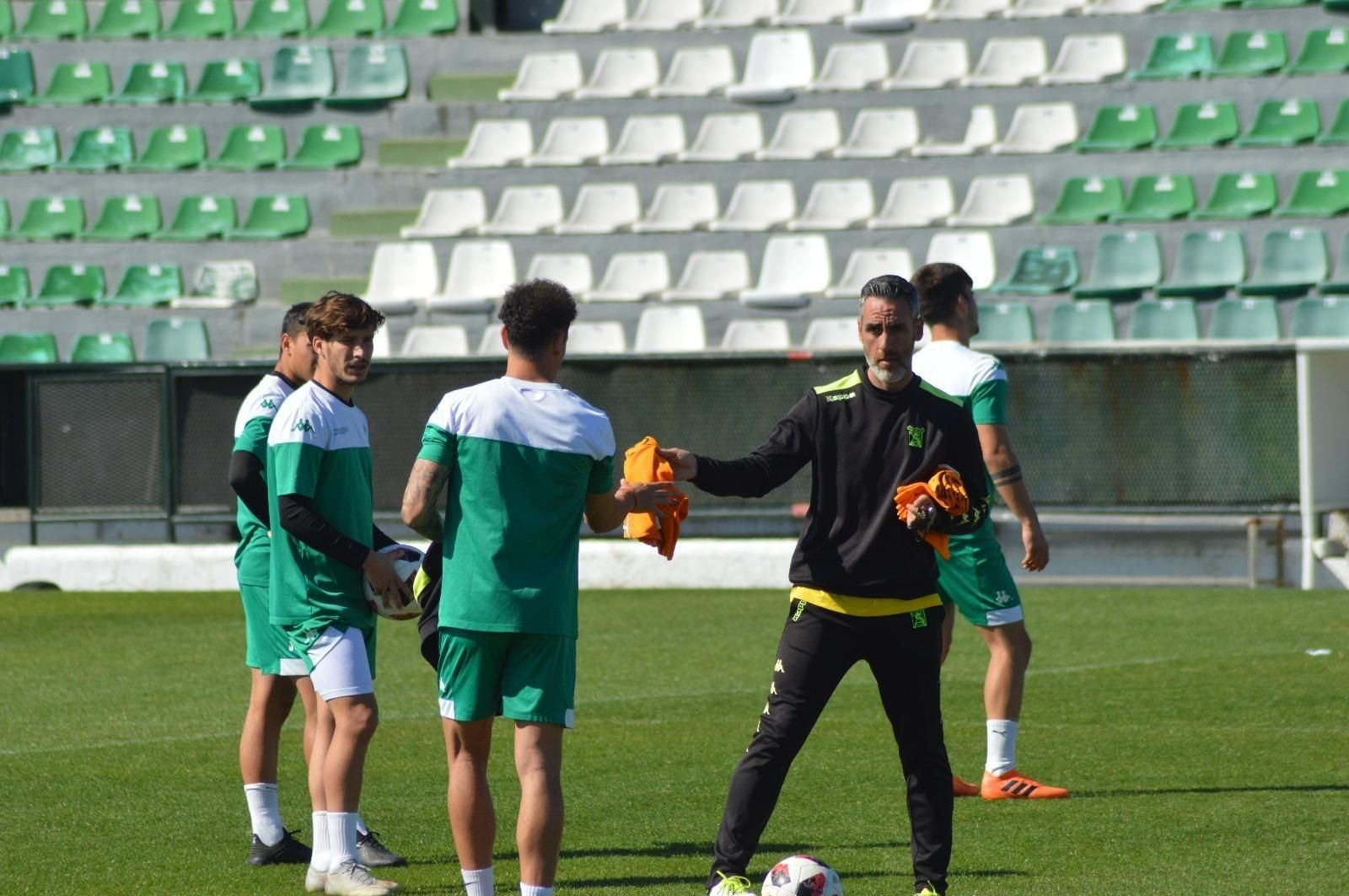 Abel Gómez reparte petos entre sus jugadores durante un entrenamiento.