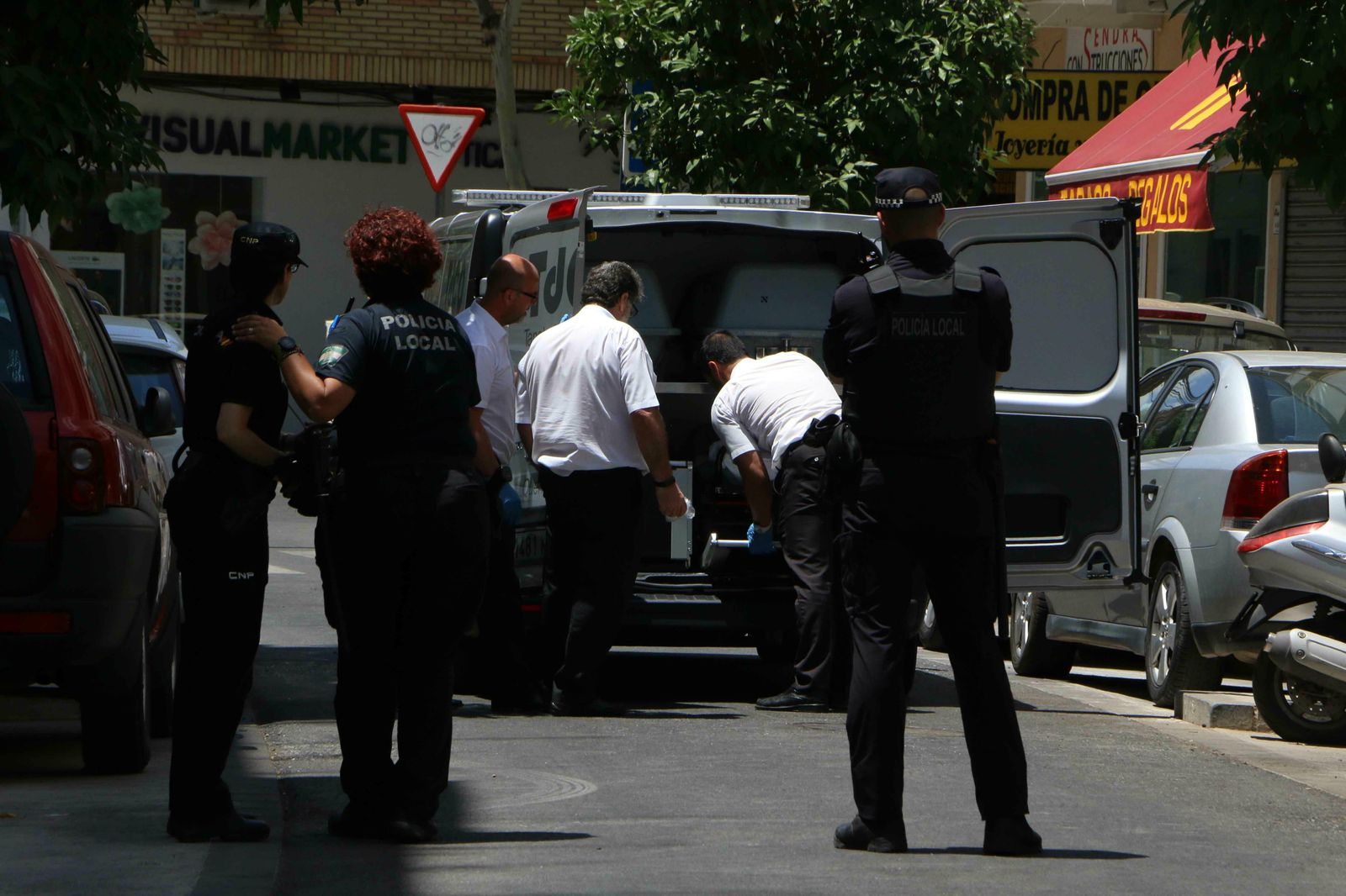 Operarios del tanatorio trasladan uno de los cadáveres.
