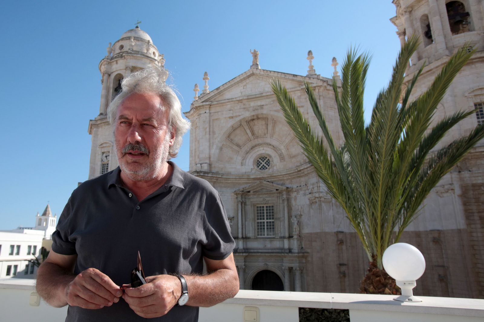 El escritor leonés Julio Llamazares, frente a la catedral gaditana.