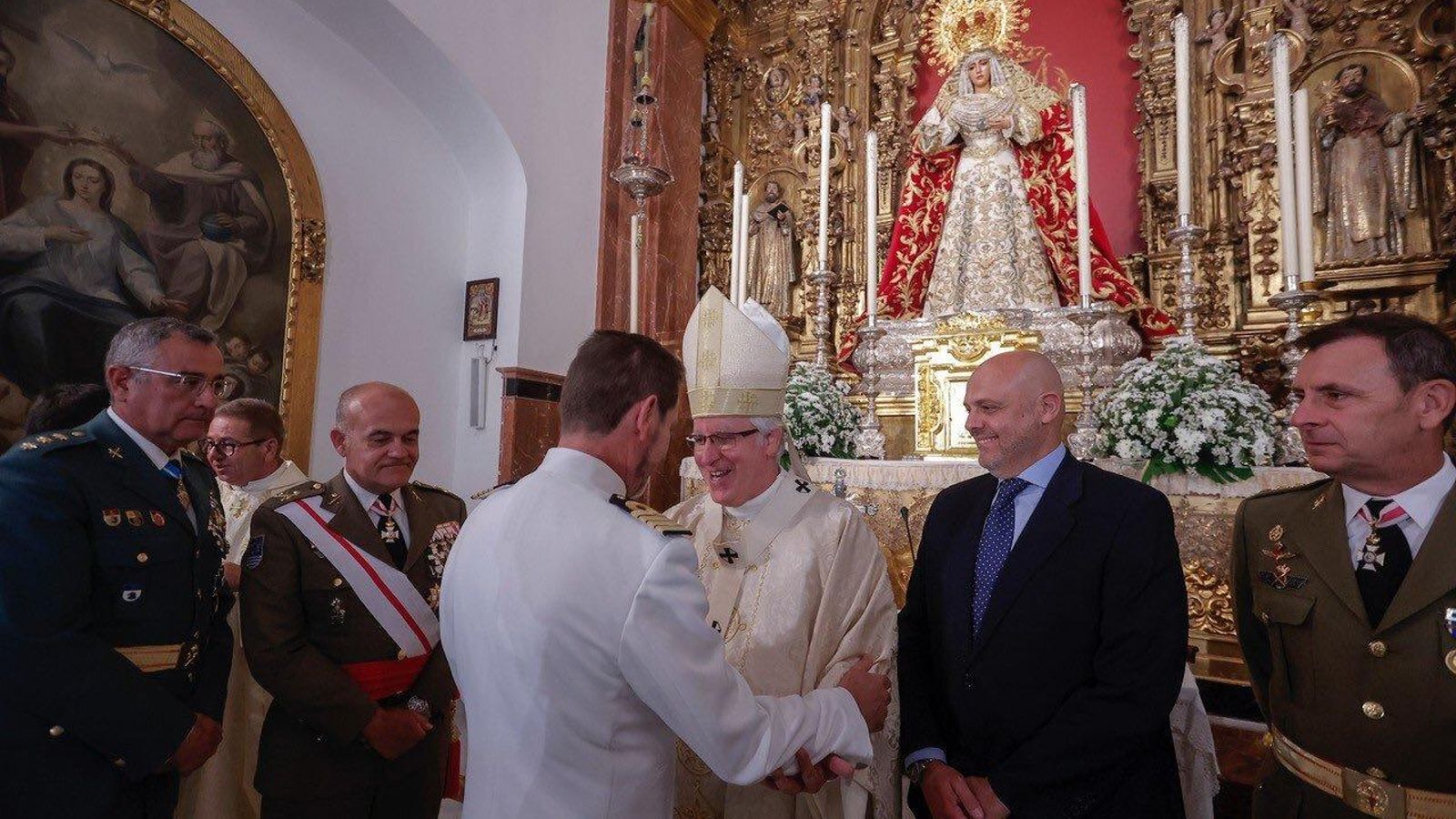 Monseñor José Ángel Saiz Meneses saluda a Daniel González-Aller, comandante naval de Sevilla, junto al resto de autoridades.